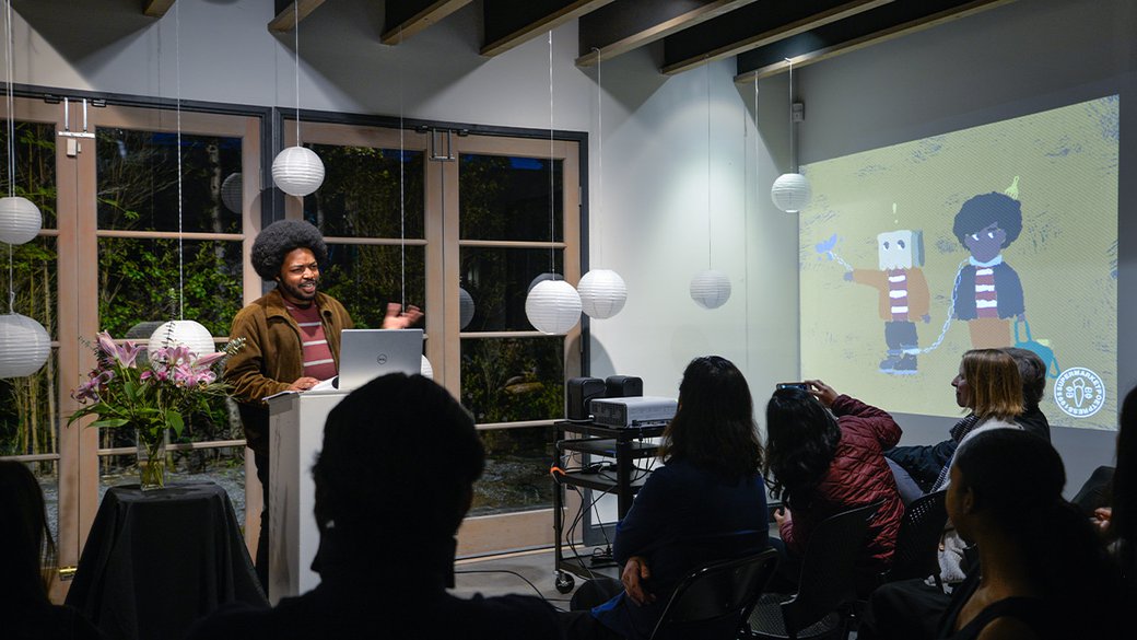 Writing and Literature student Jevohn Newsome presents to a group of people at his Senior Reading, Spring 2019.