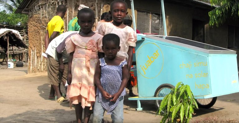 Children standing in front of a Juabar charging station