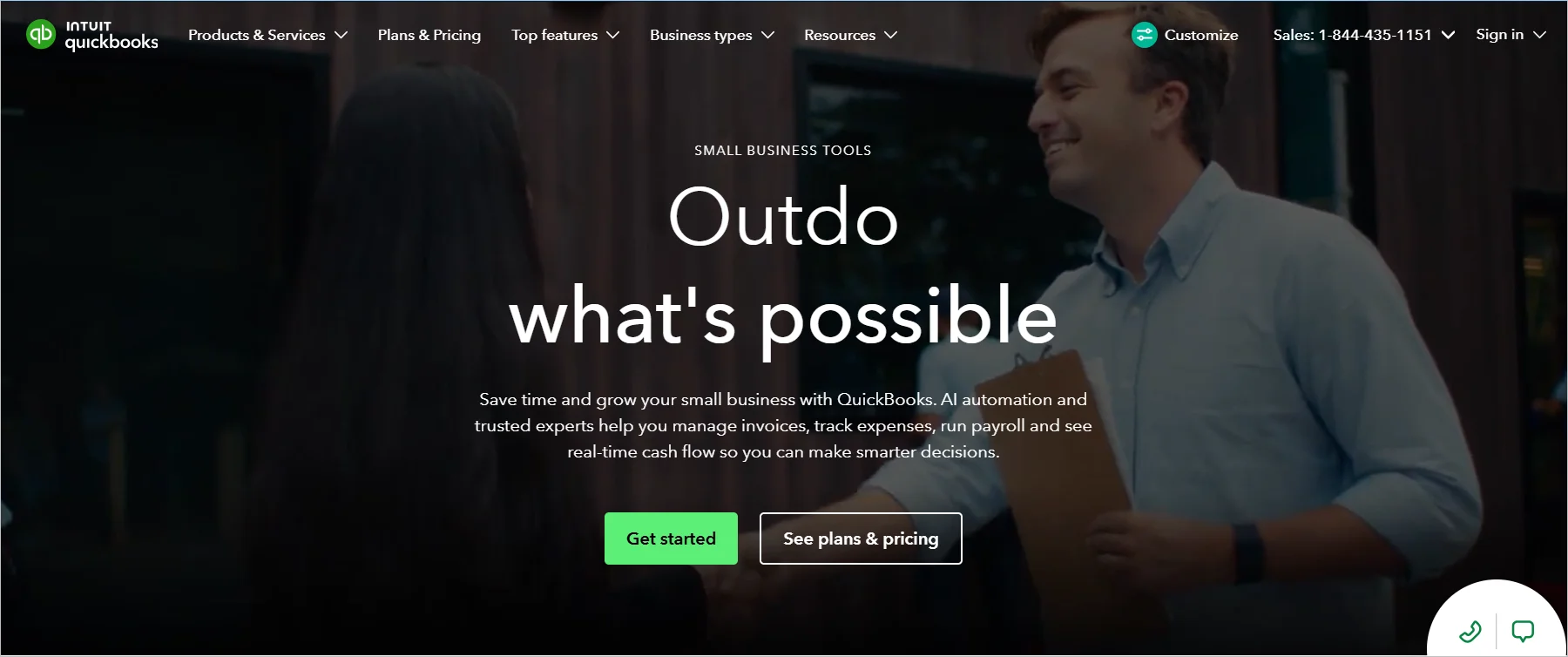QuickBooks webpage with the text “Outdo what’s possible,” featuring navigation links, action buttons for getting started, and a background workplace setting.