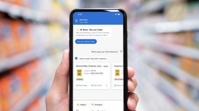 An associate is holding a phone, interacting with Ask Sam, Walmart’s voice assistant for in-store associates. 