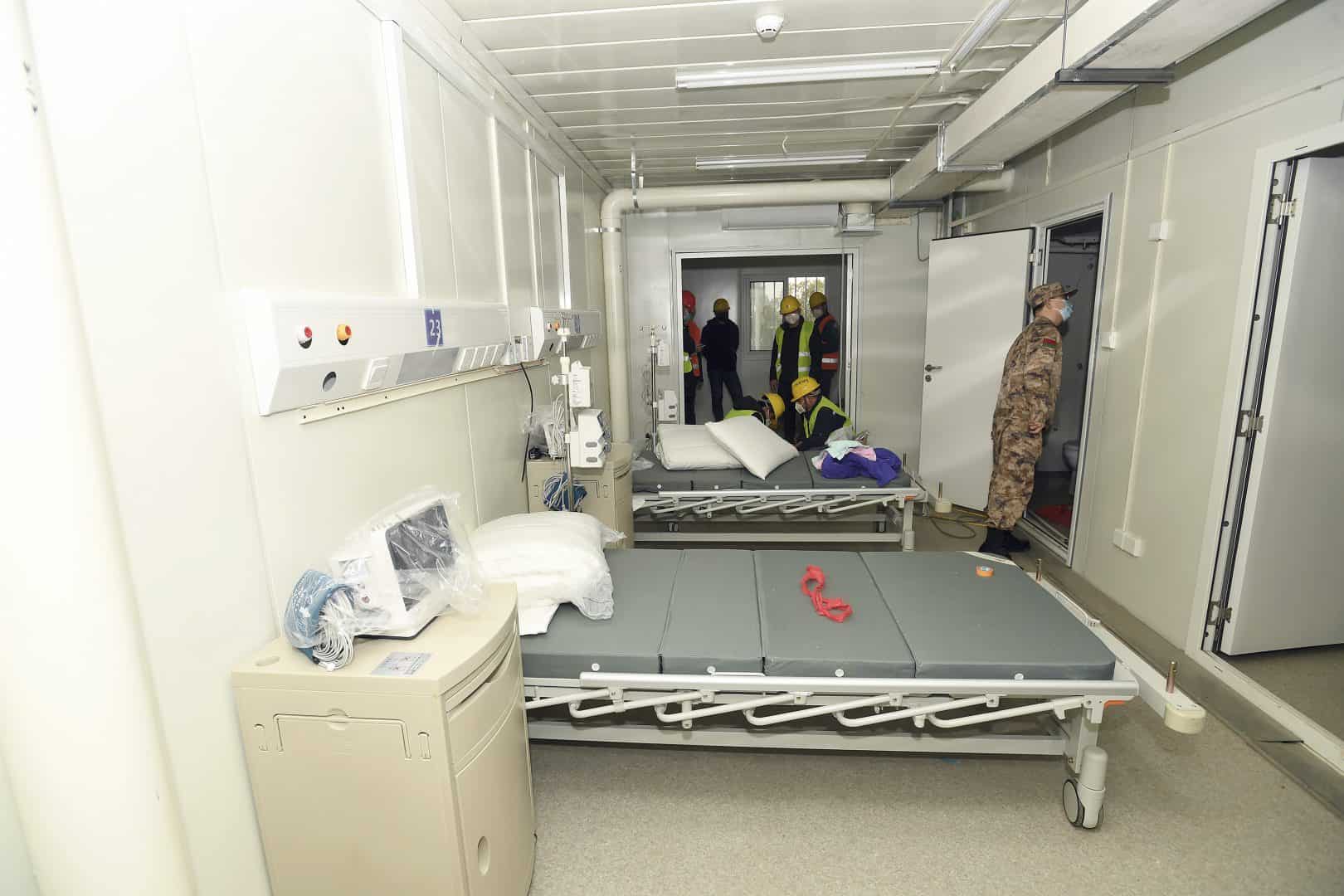 A Chinese army medic looks at a patient room at the Huoshenshan temporary field hospital in Wuhan (Chinatopix/AP)