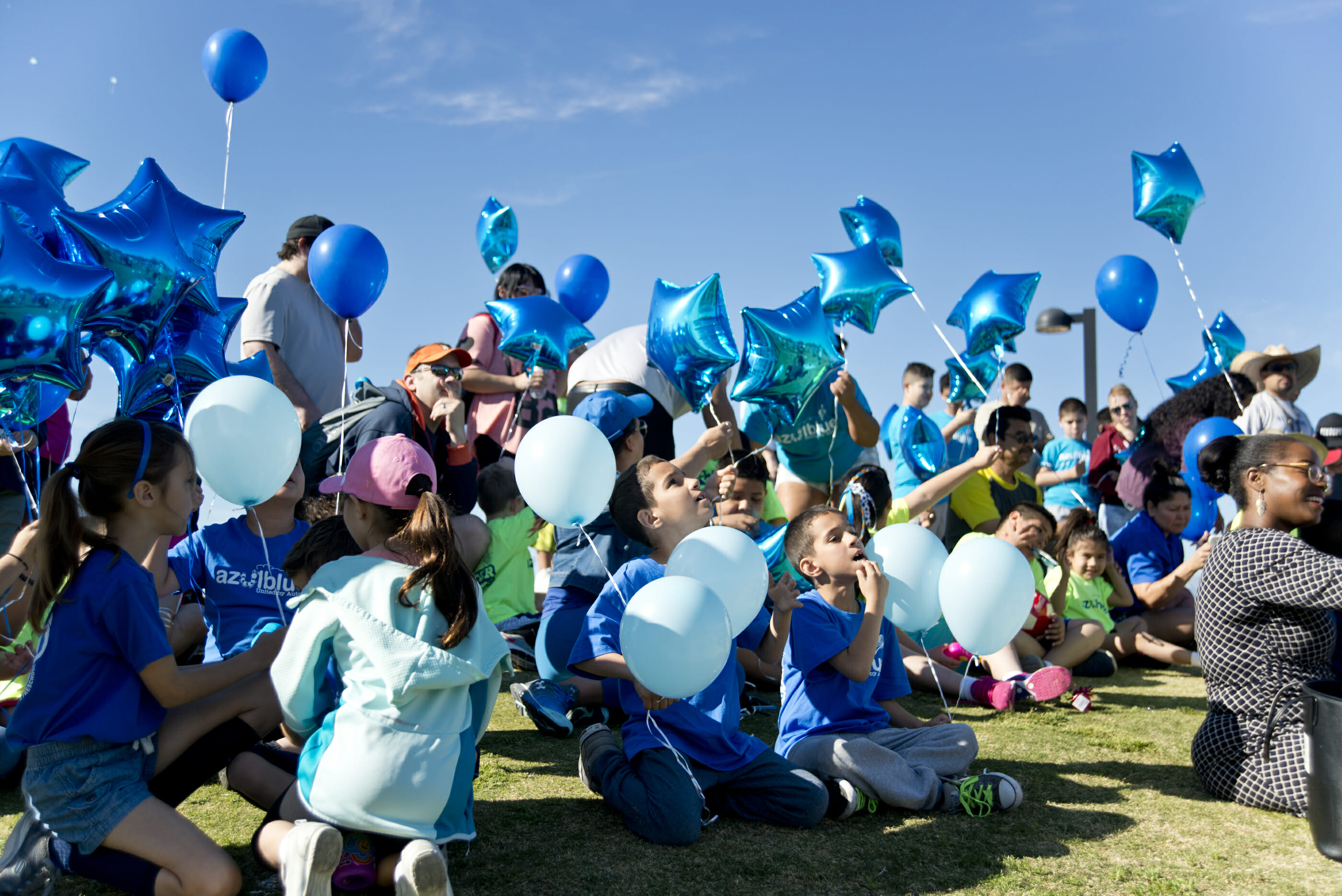 A group of people releasing blue balloons