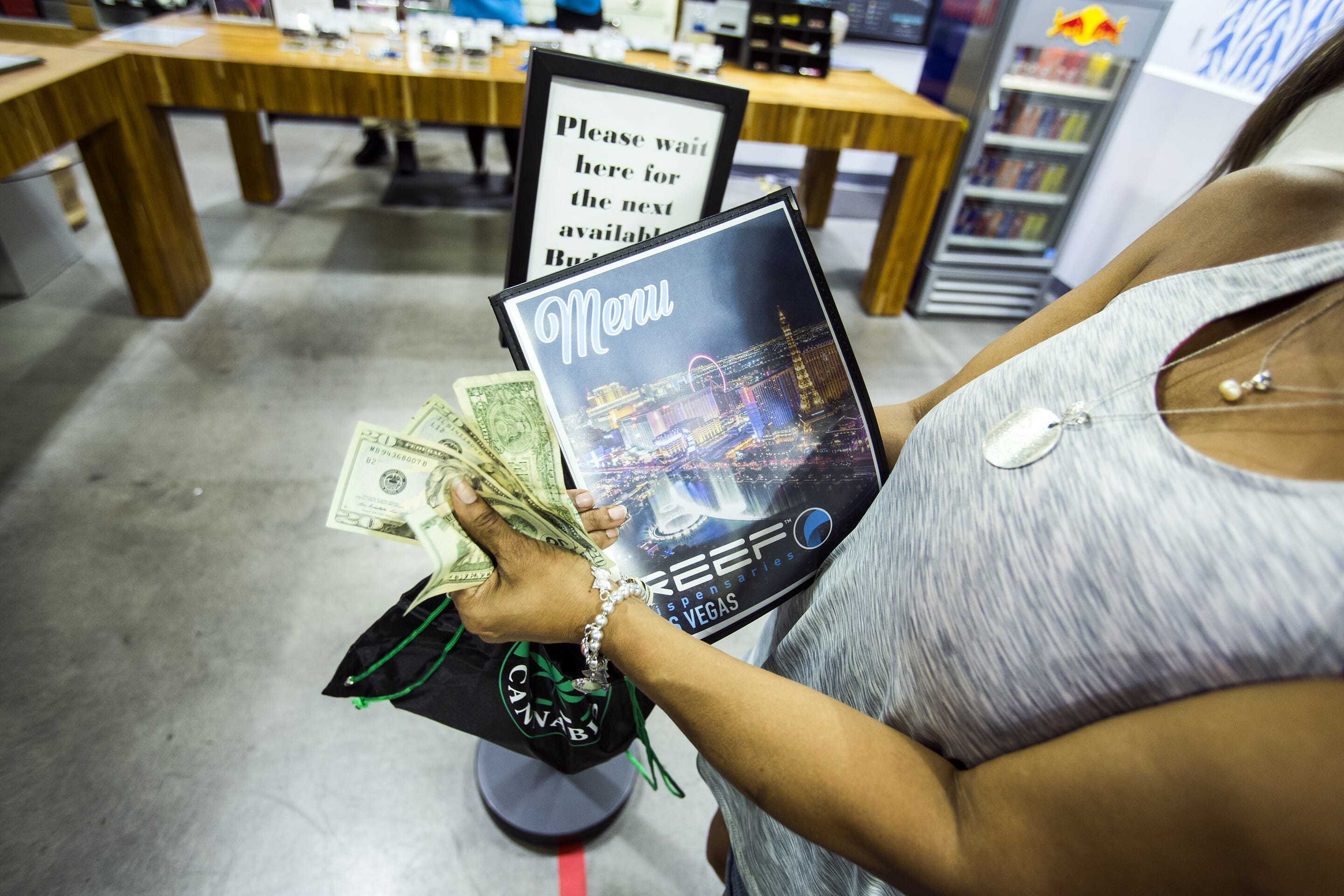 Woman holding money at dispensary