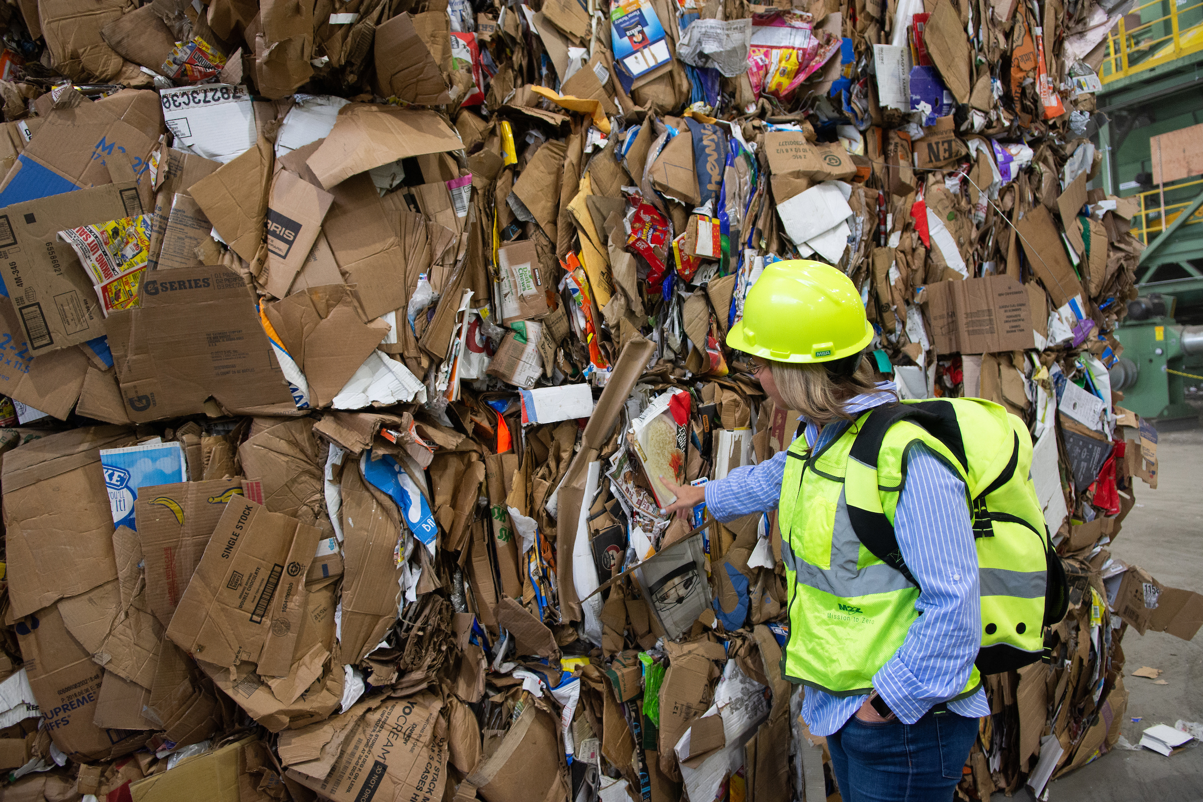 Kendra Kostelecky, a spokesperson for Waste Management, points out contamination of a cardboard bundle during a tour inside the recycling center in Reno, Nev.