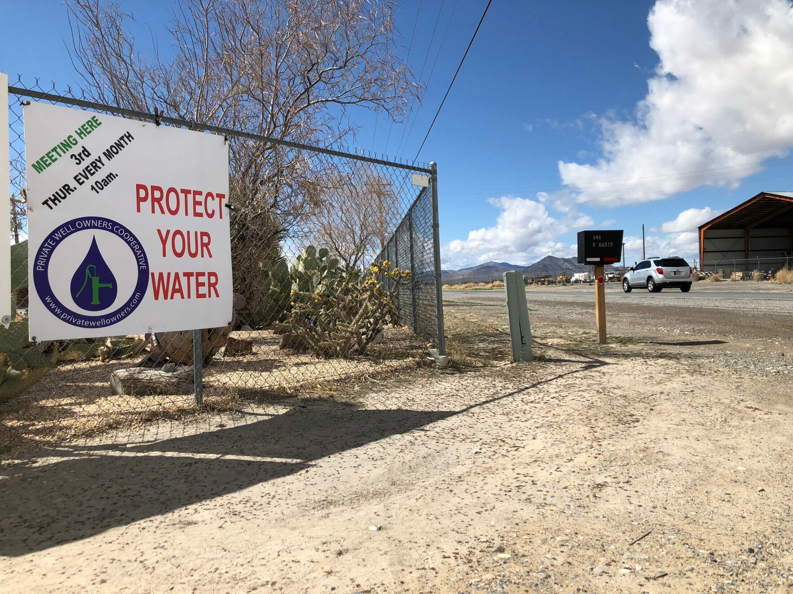 A sign on a fence saying "protect your water"