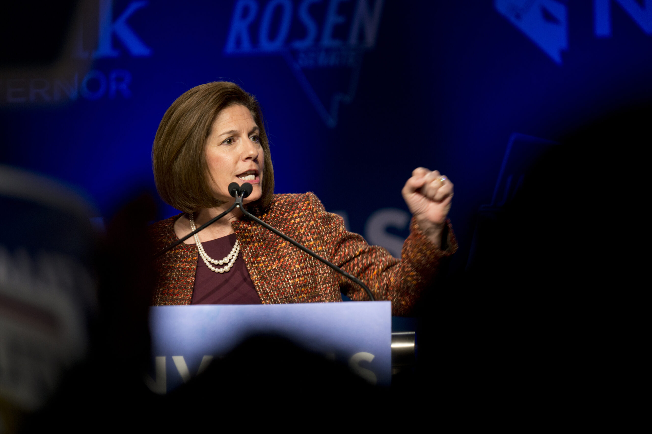 Senator Catherine Cortez Masto speaking into a microphone behind a podium