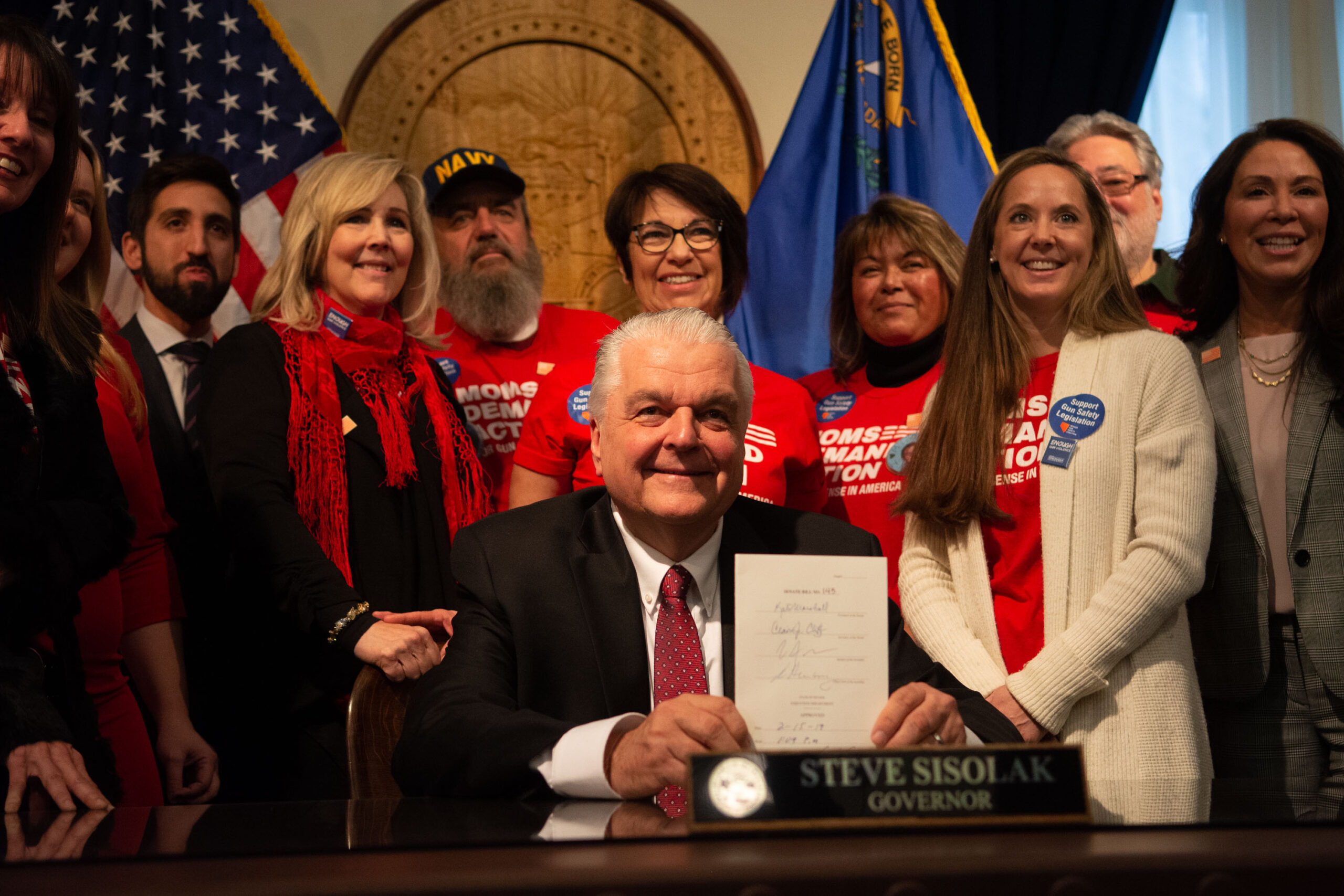 Gov. Steve Sisolak holds a signed copy of SB143, which would require background checks on most private gun sales and transfers, after signing it on Feb. 15, 2019