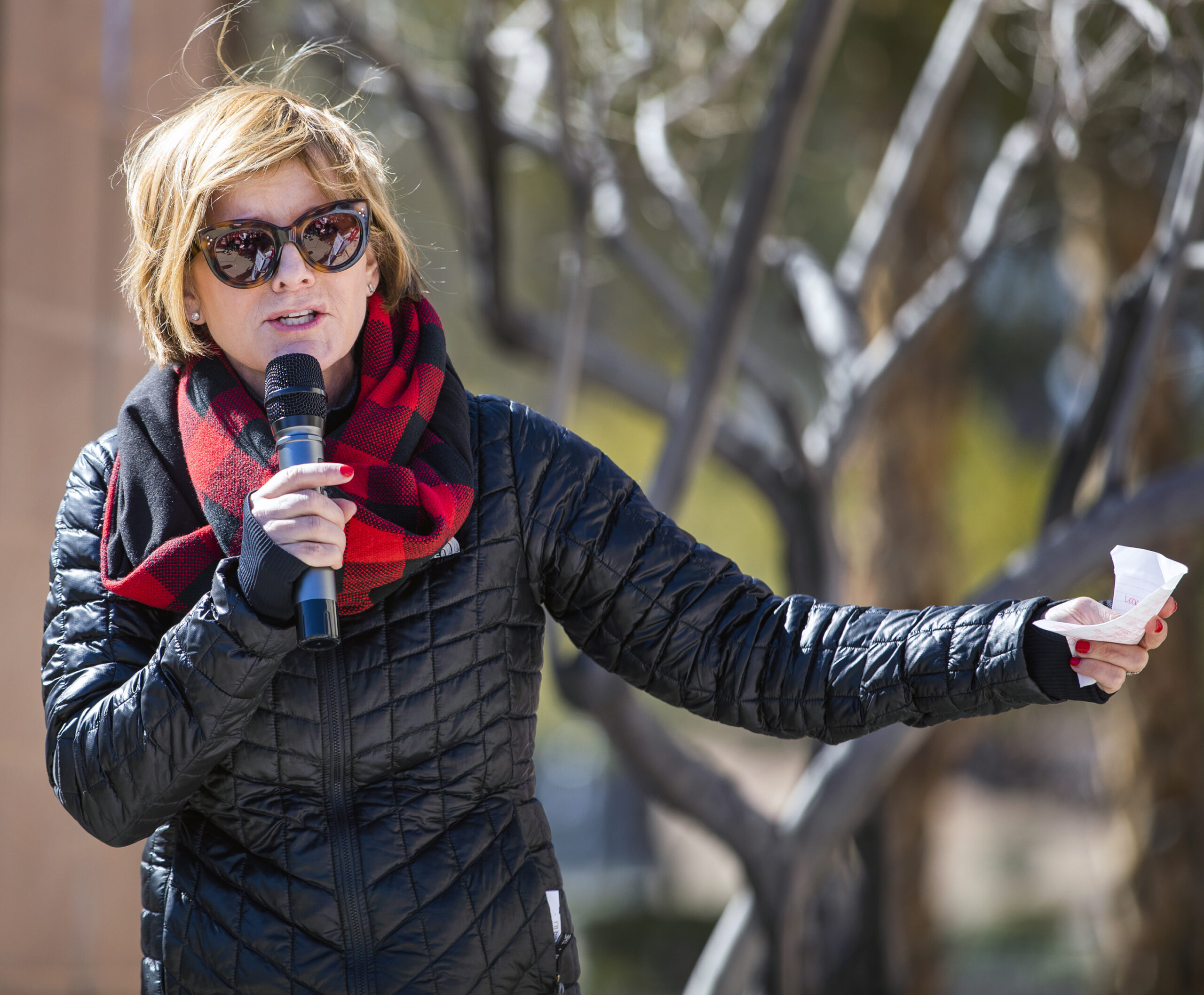 Susie Lee in a jacket and red scarf at an event