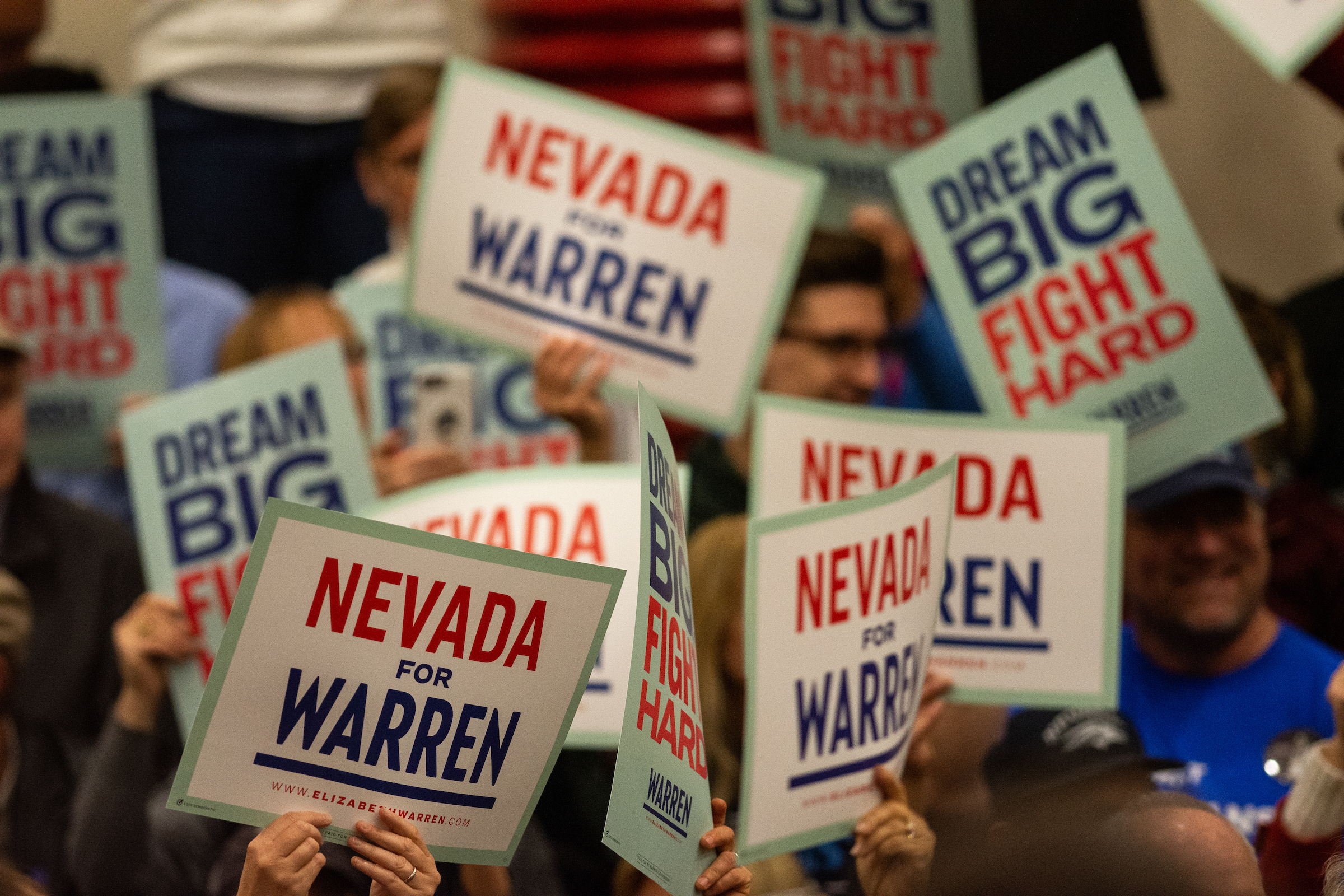 Signs being held up reading Nevada for Warren and Dream Big Fight Hard during a campaign rally