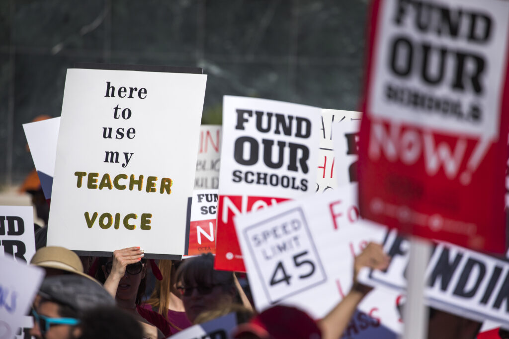 Rally signs saying "Fund Our Schools"