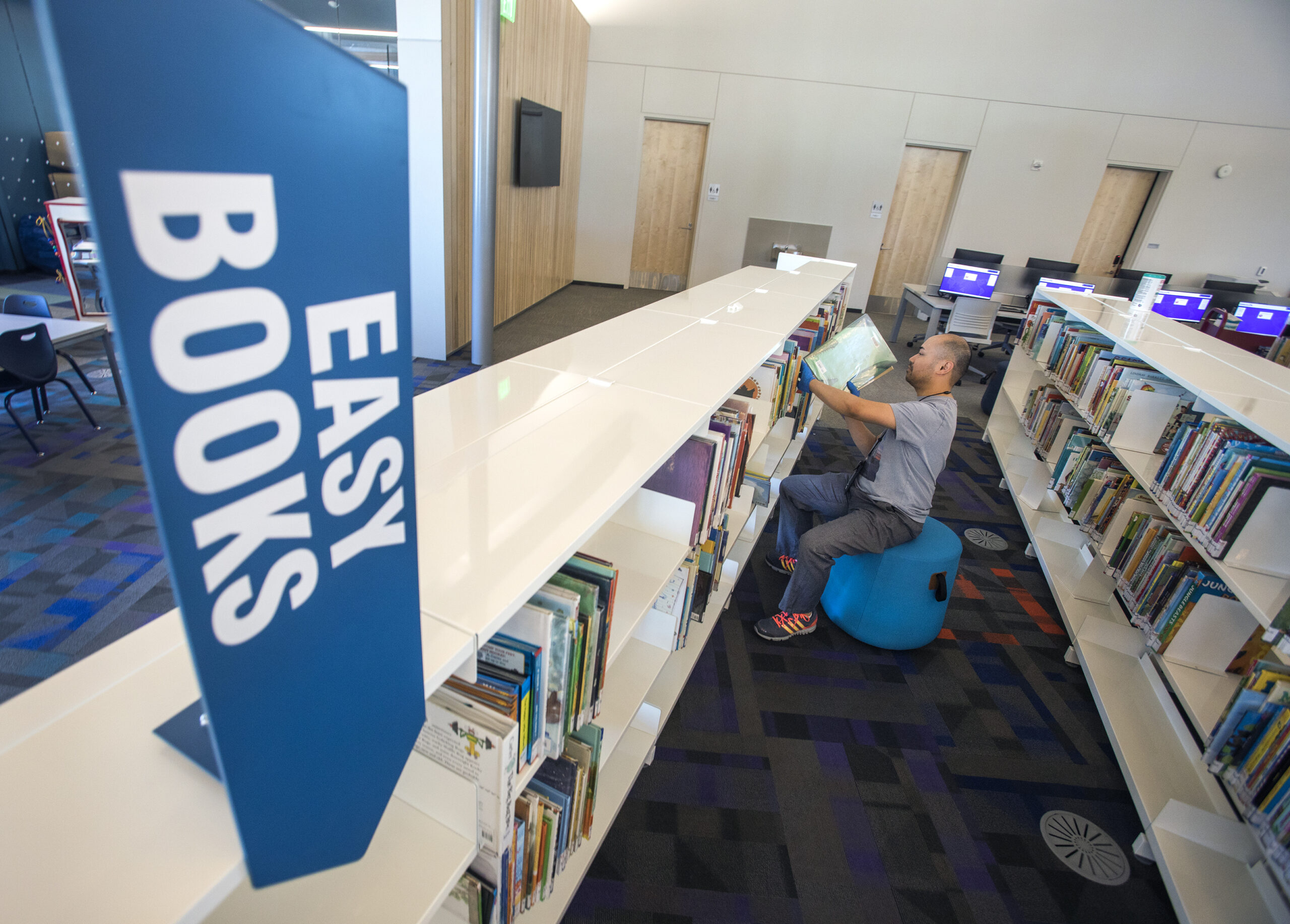 person shelving books in library