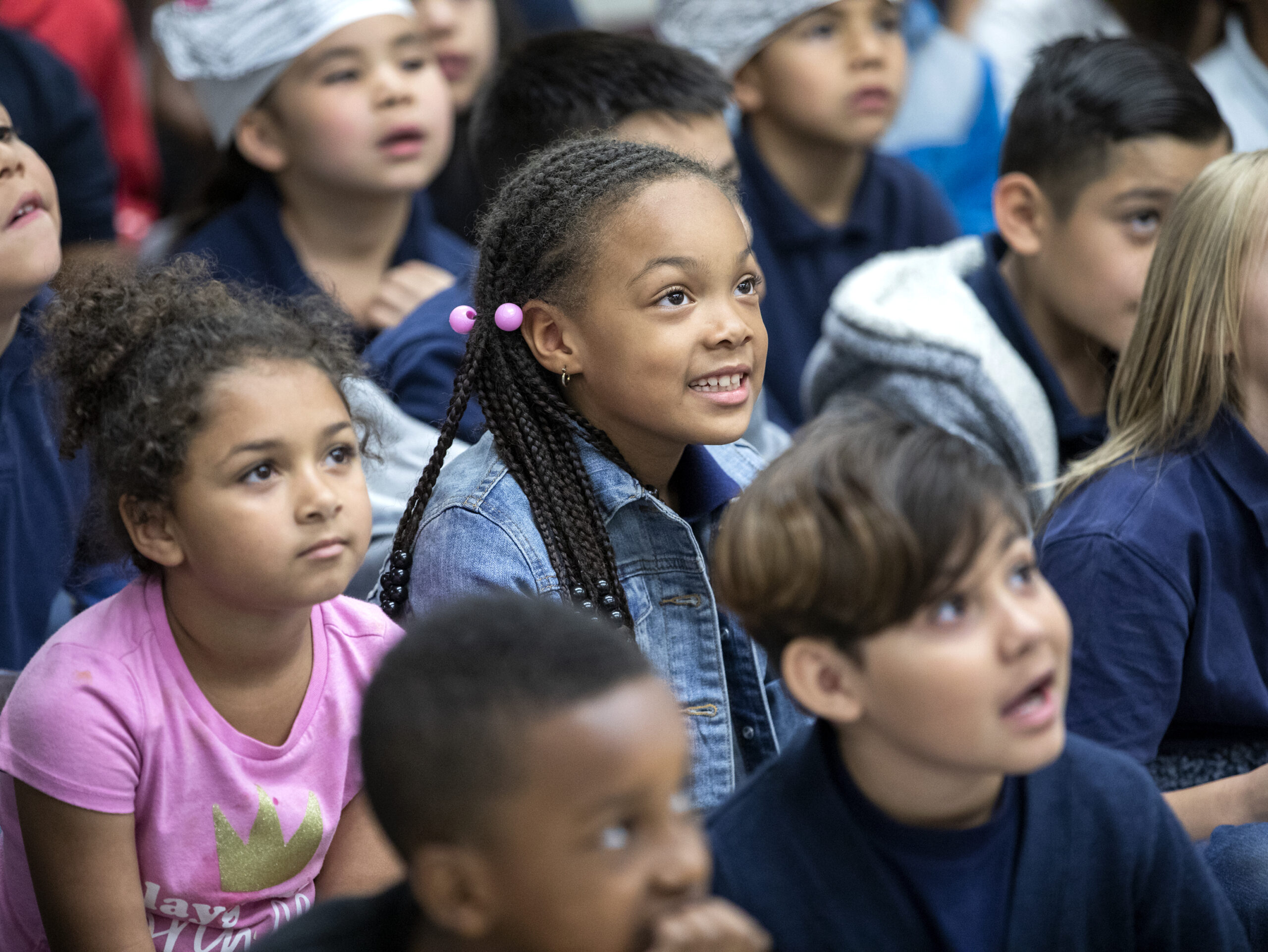 A small group of kindergarten age children sitting on a floor