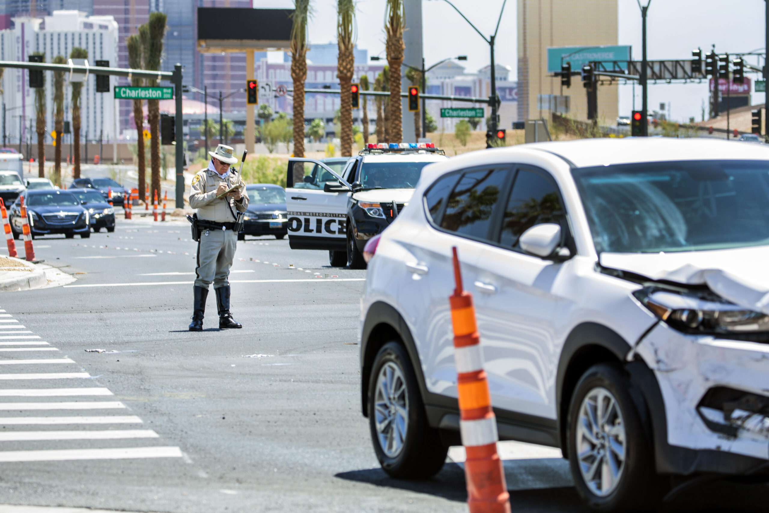 A police officer stands at the scene of a traffic accident.