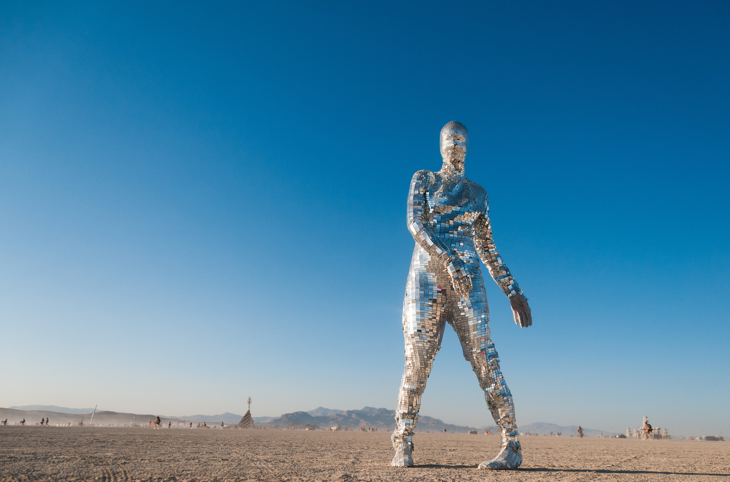 A person in a mirrored suit at Burning Man.