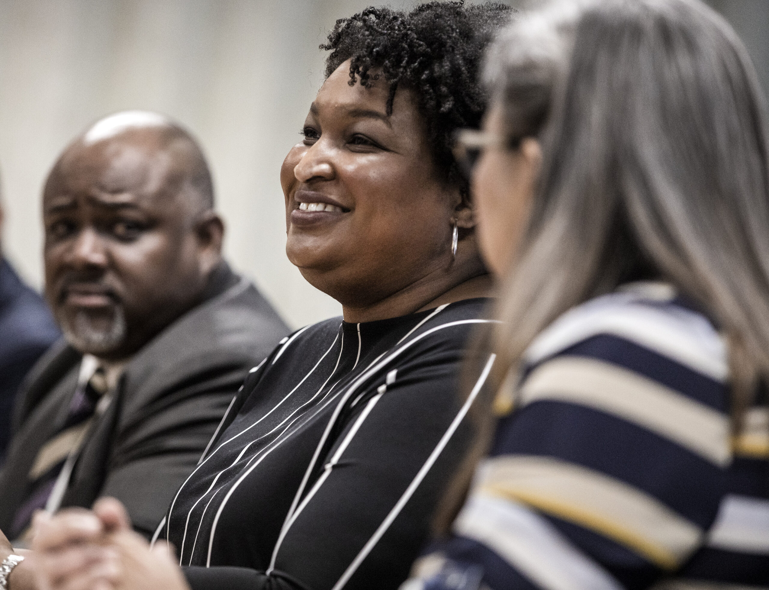 Stacey Abrams, center, with two attendees on either side,