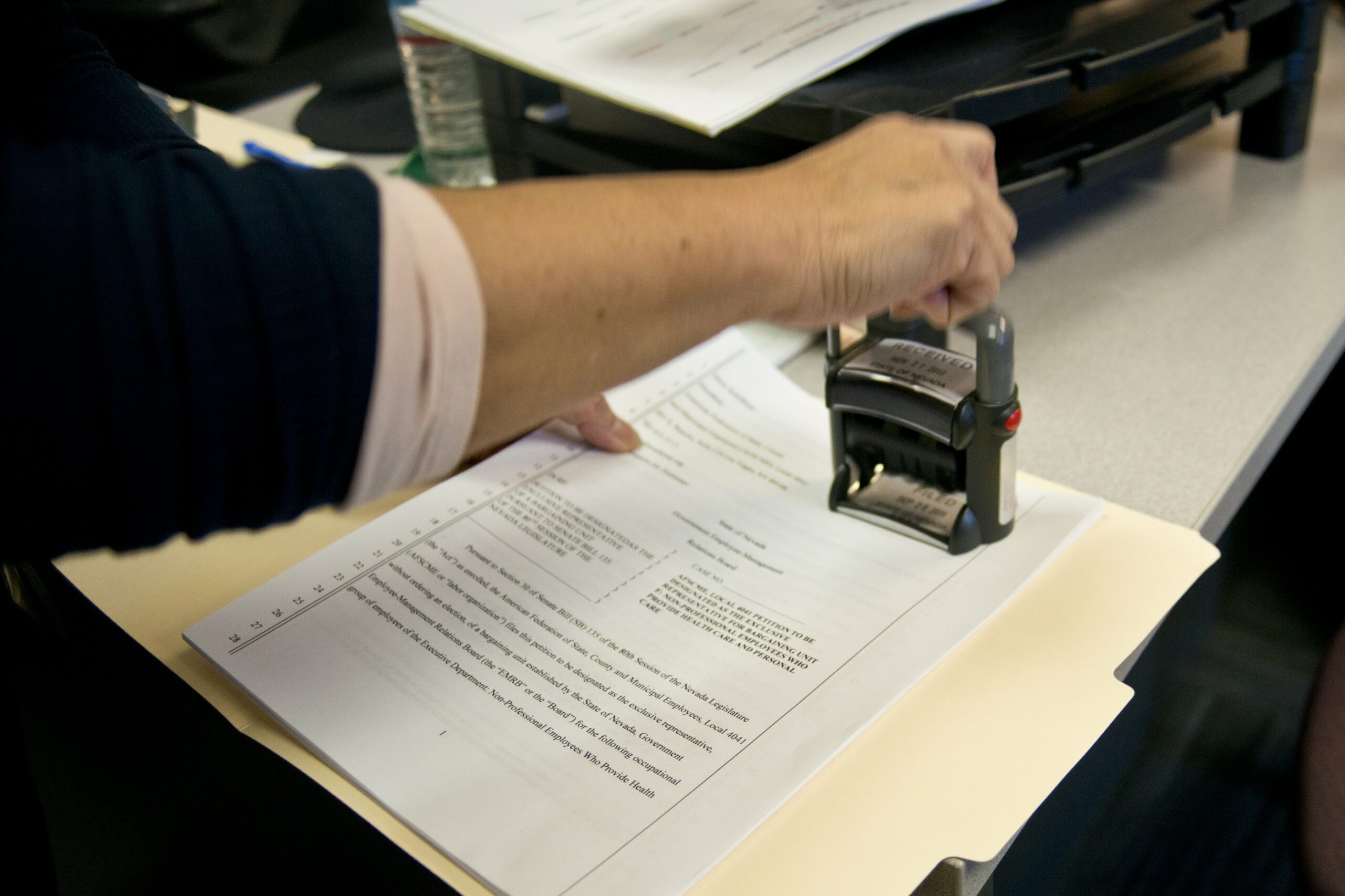 Someone affixing a stamp on documents