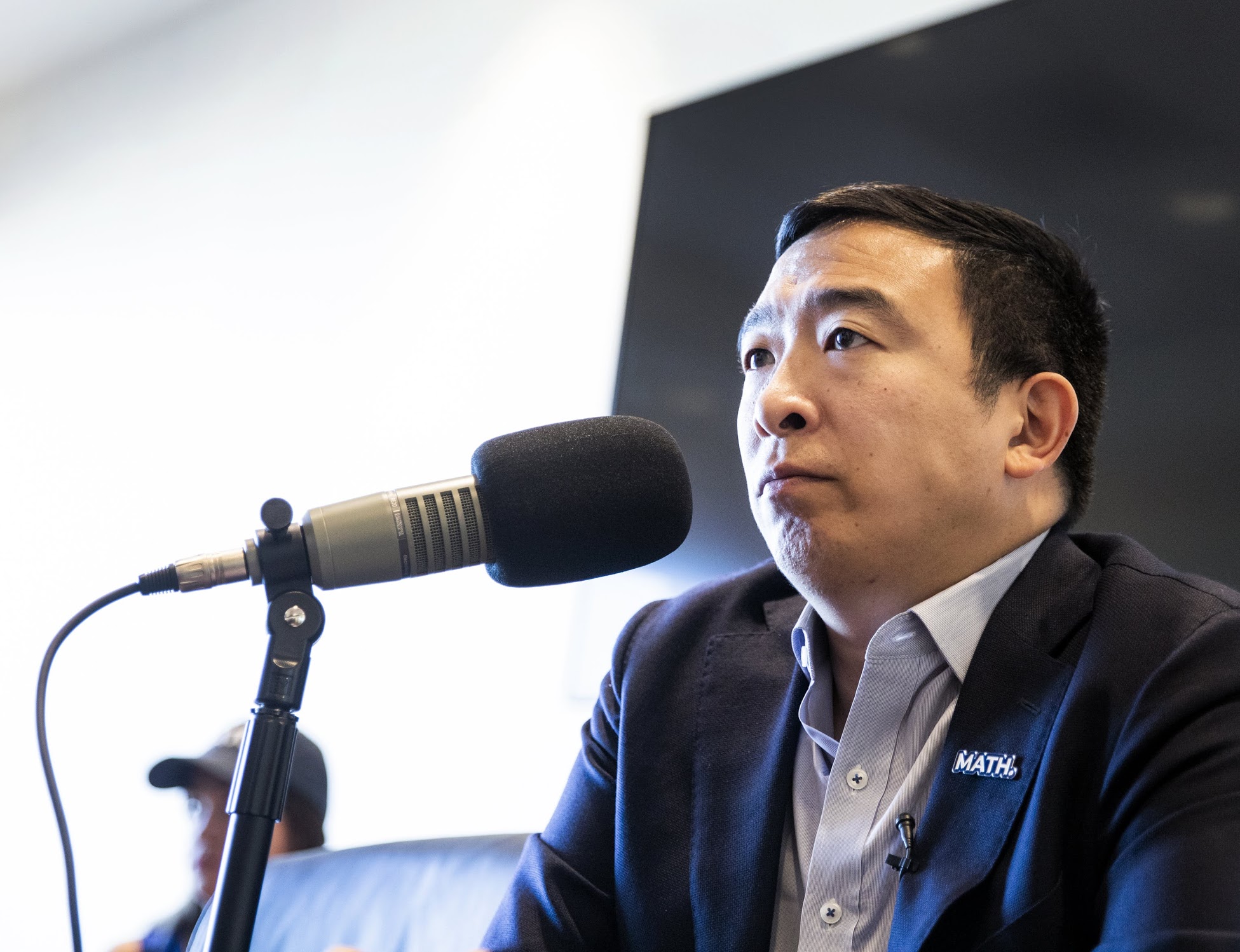 Andrew Yang speaks into a microphone