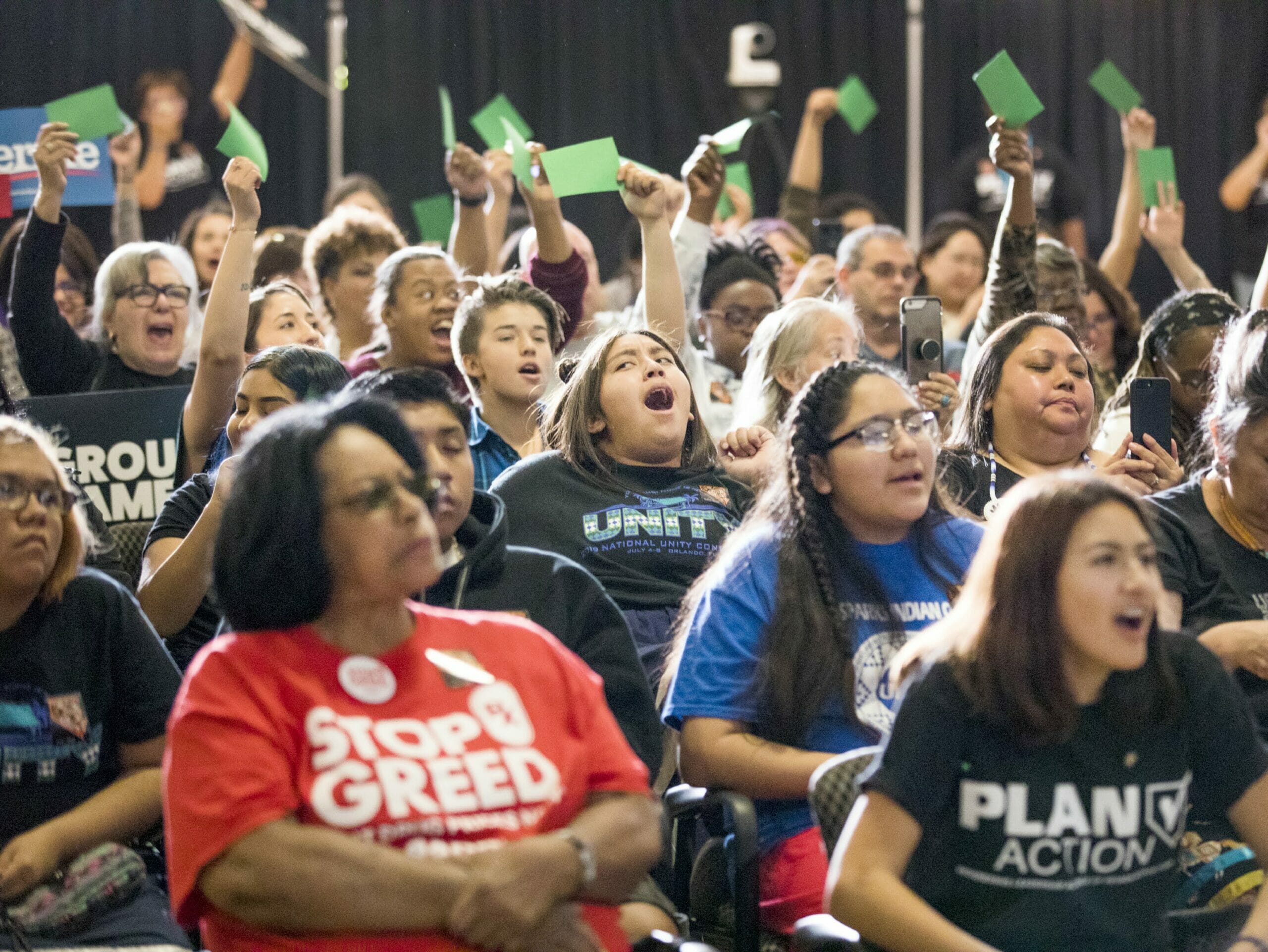 People cheer at a forum