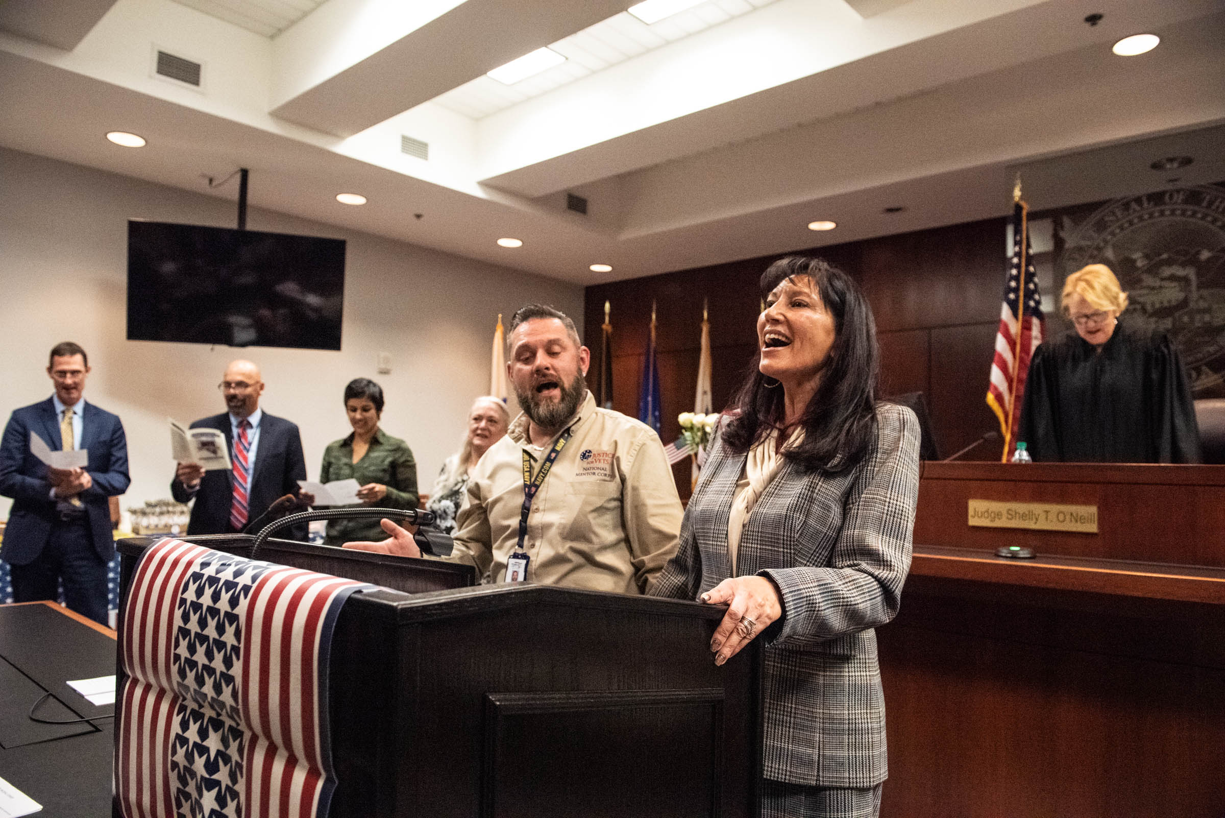 Veterans court administrators singing