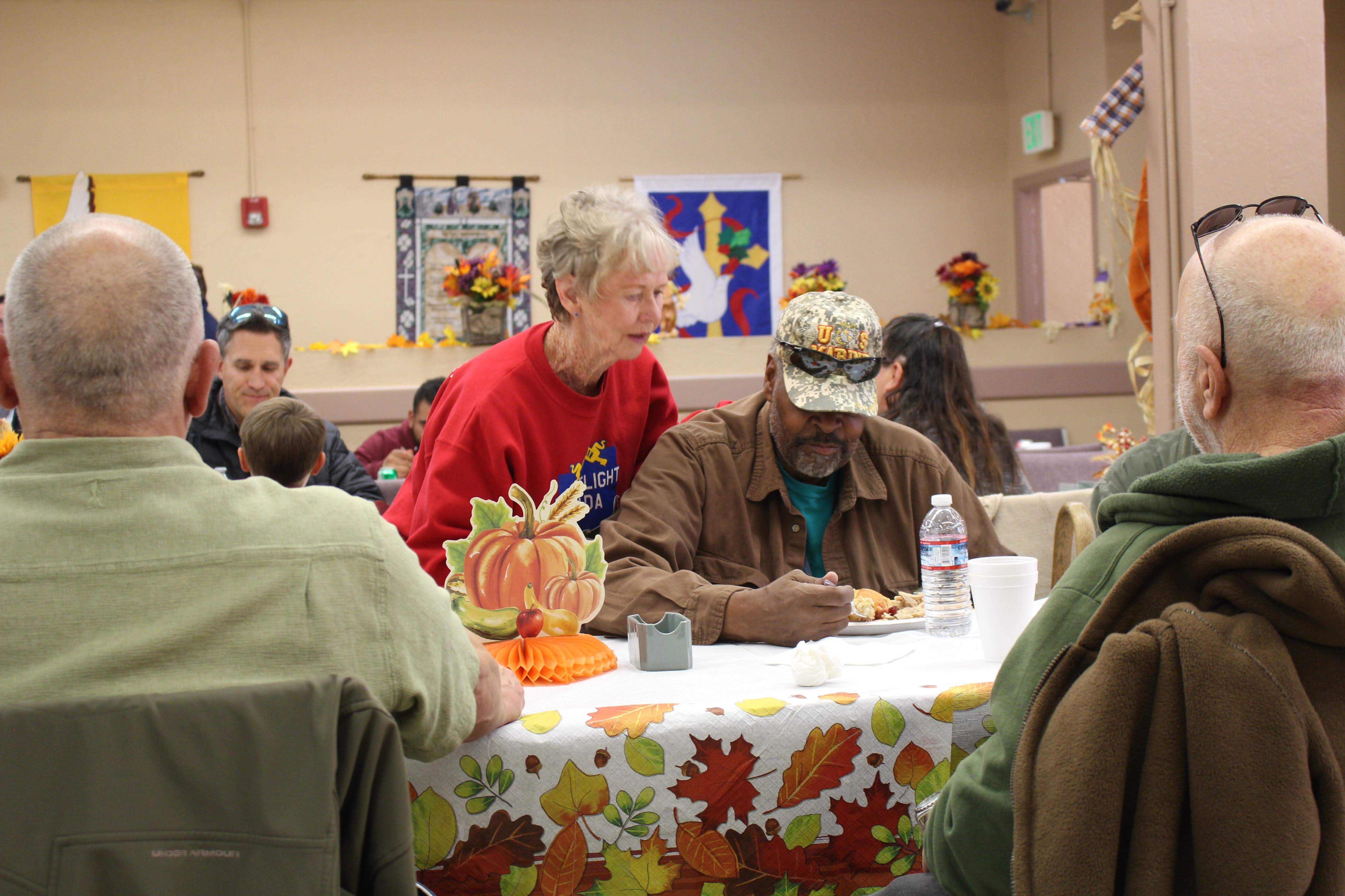 Volunteer talks with veteran at Thanksgiving meal