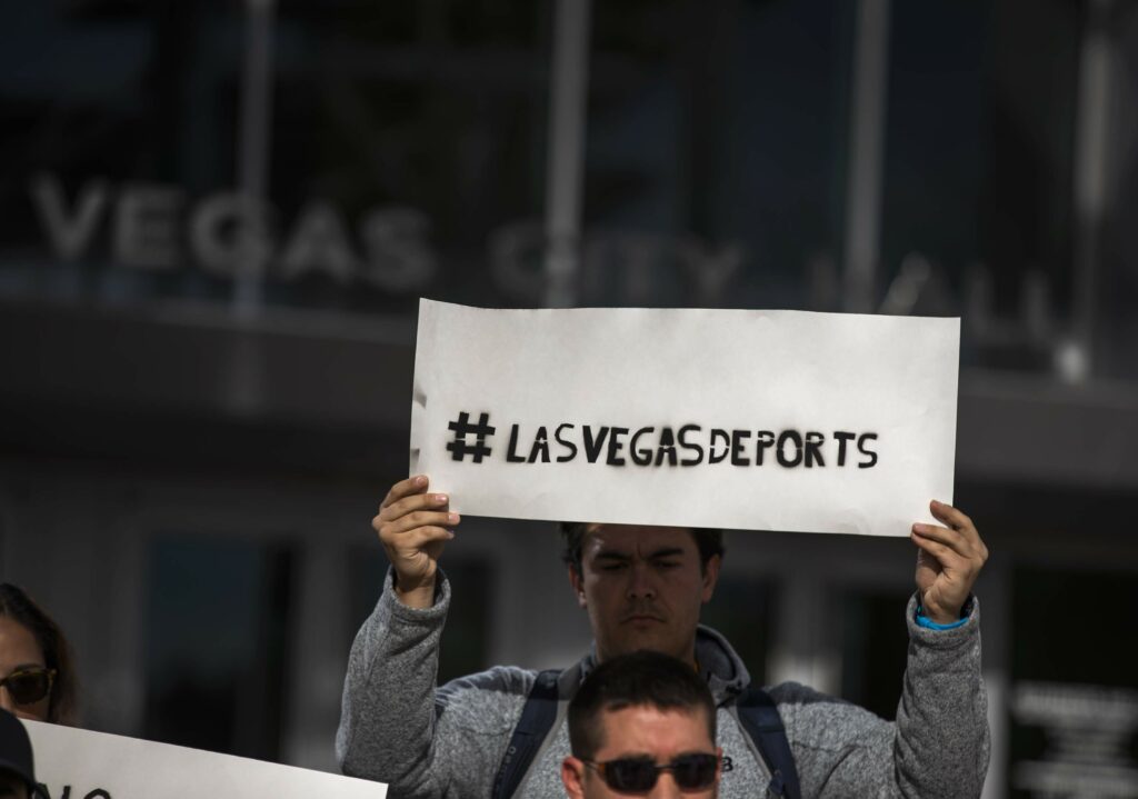 Man holds sign saying Vegas deports