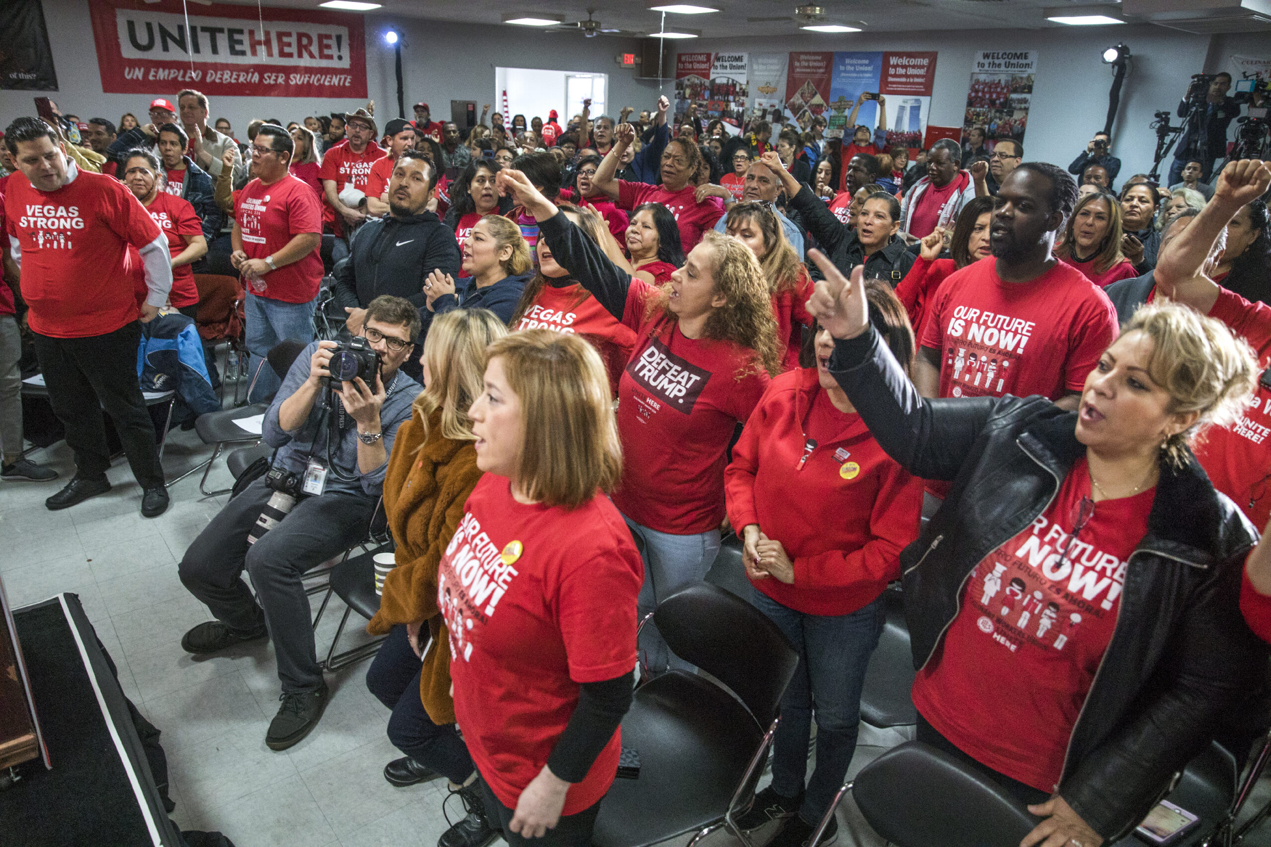 Union members in red shirts at a town hall event