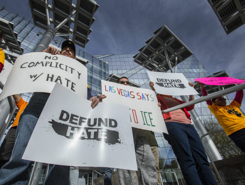 People hold sign saying defund hate