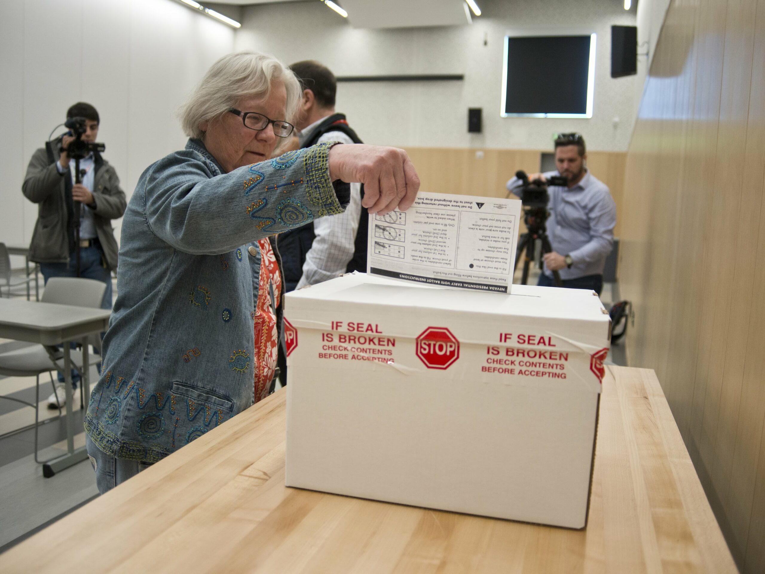 Carleen Marinez turns in her completed preference card during the first day of early voting for the Nevada Caucus at the East Las Vegas Library