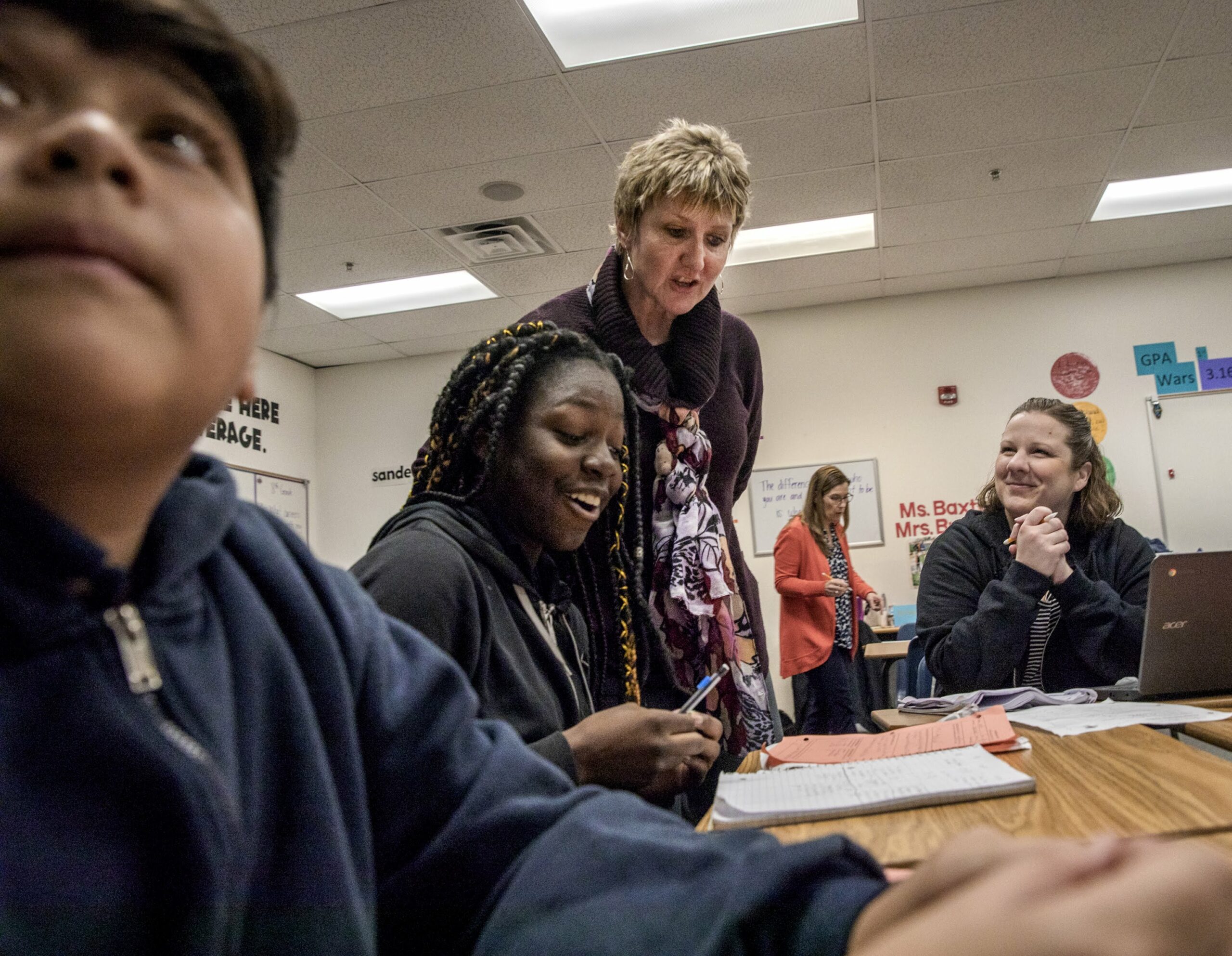 Jerome Mack Middle School Principal Roxanne James standing behind students seated at a table