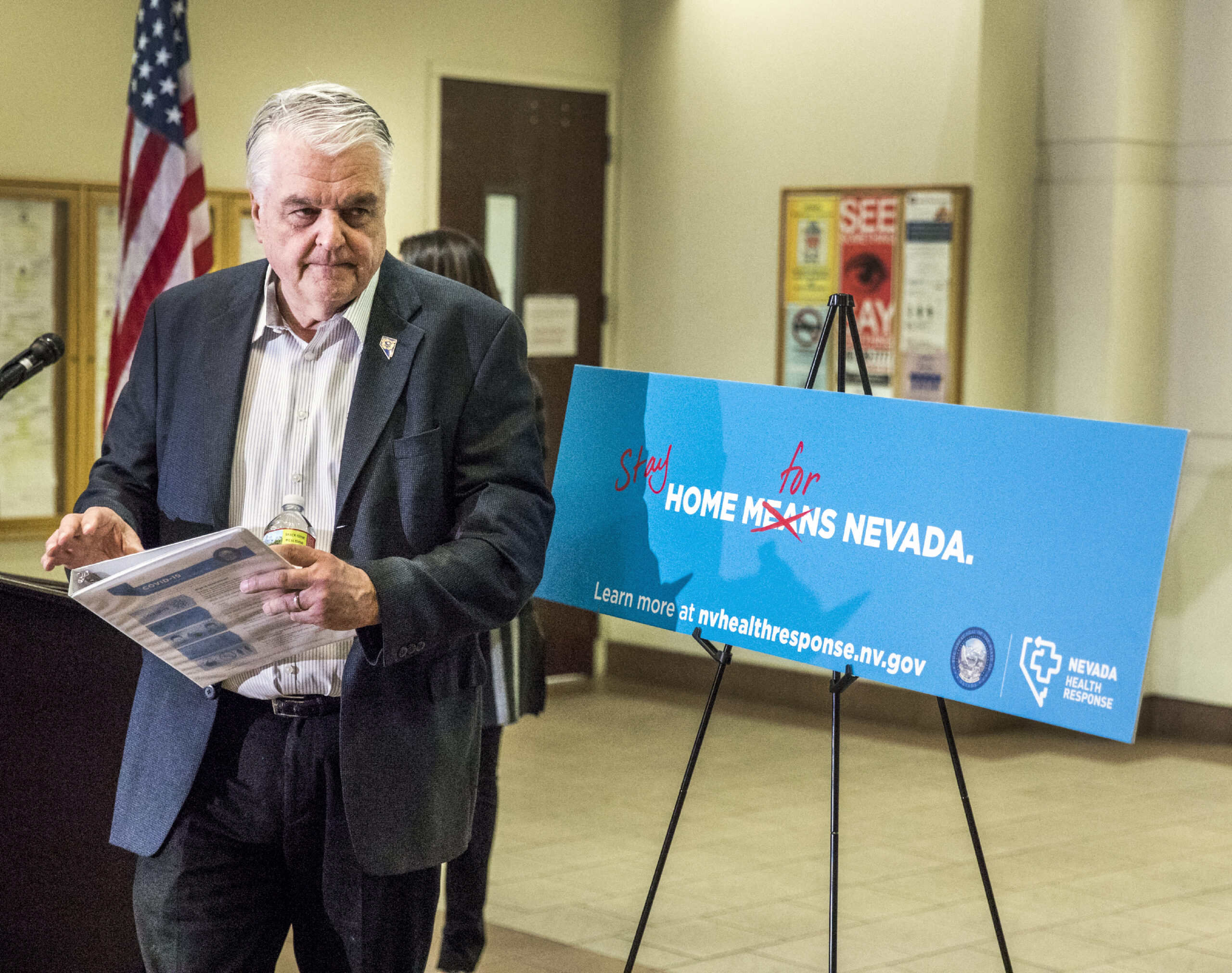 Steve Sisolak stands away from podium