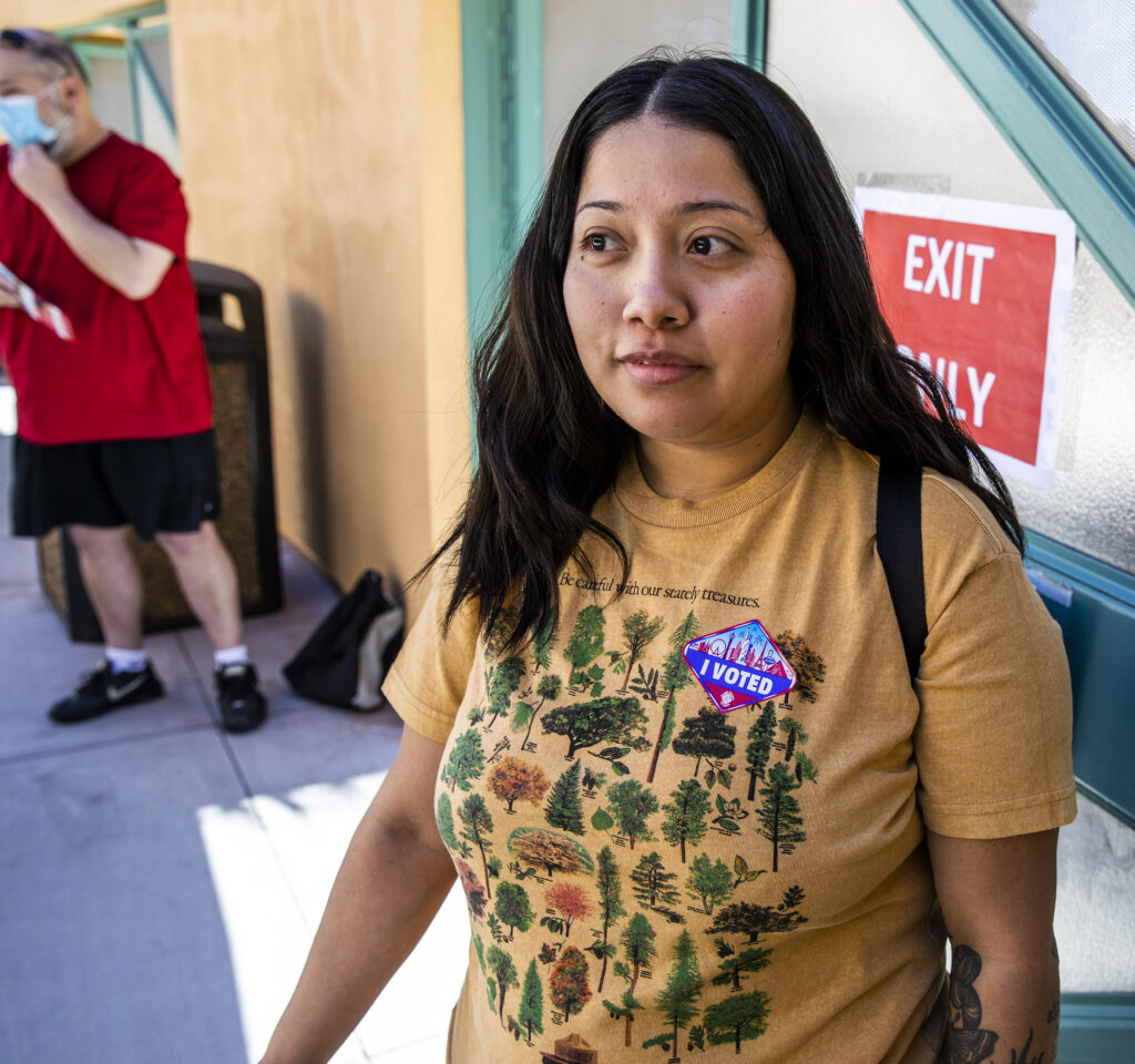 A woman stands outside a voting center.