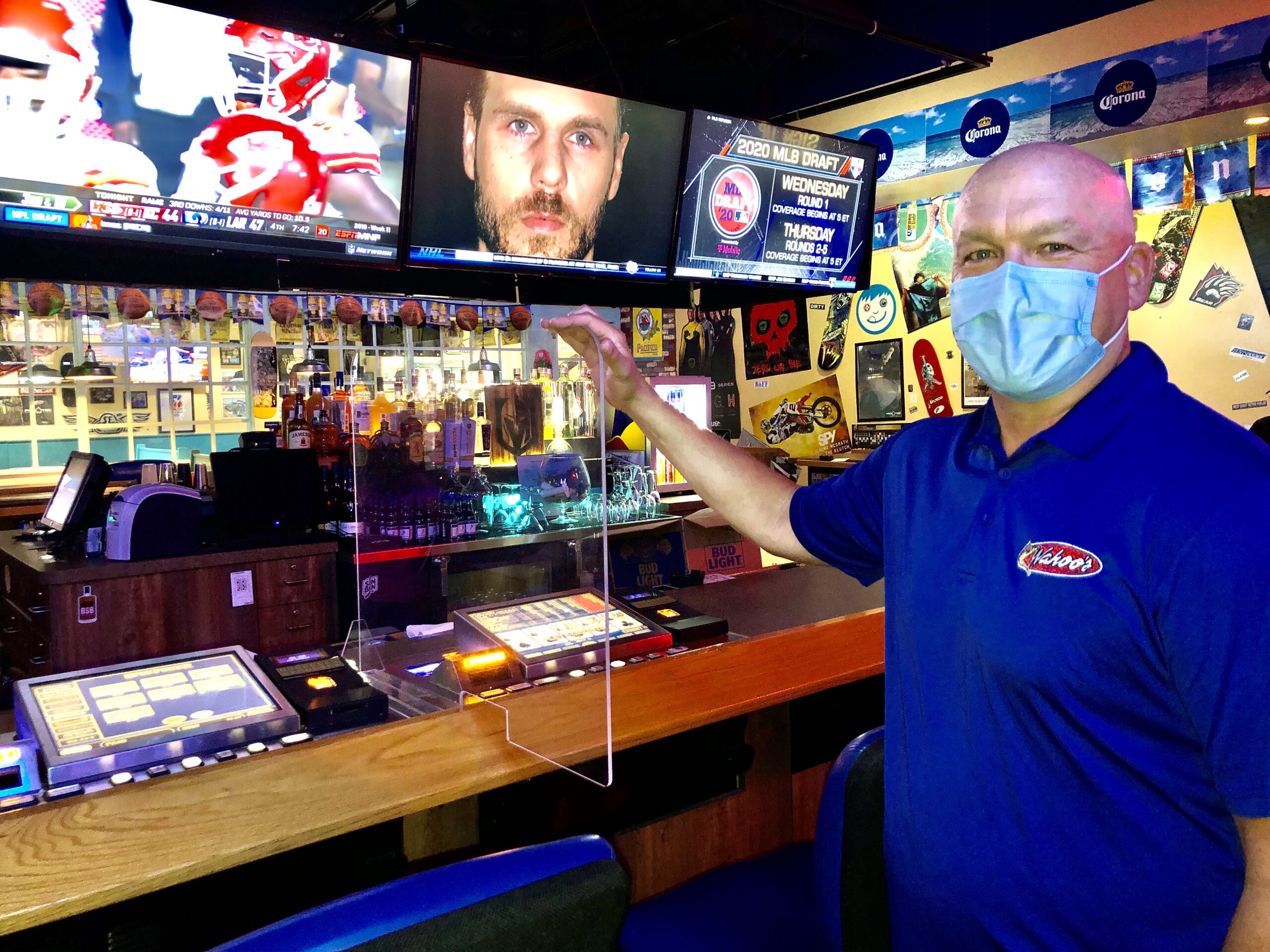 Wahoo’s Fish Tacos owner Matt Flandermeyer shows off one of the plexiglass dividers between two bar top slot machines at his tavern on Sunset Road and Rainbow Boulevard.