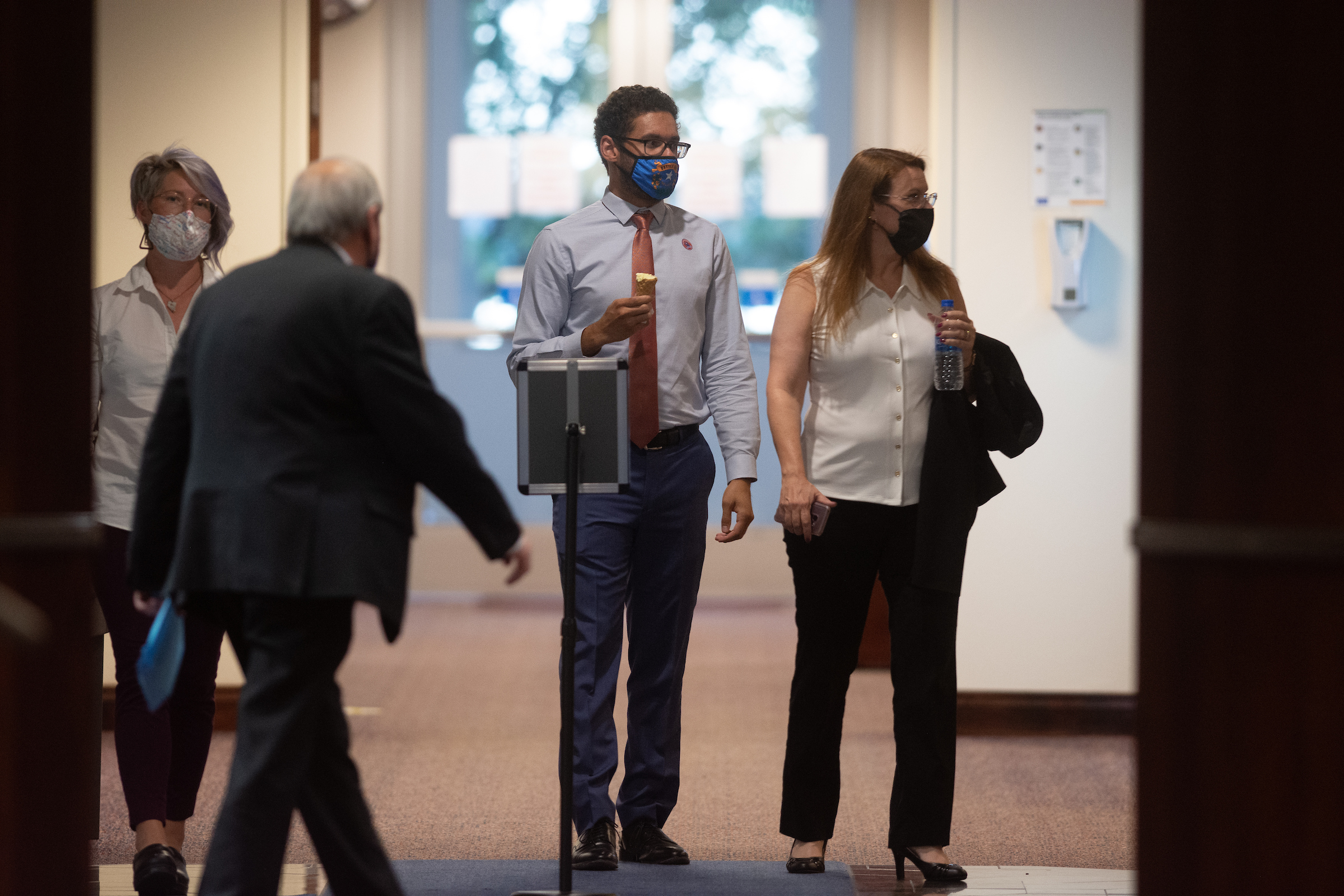 Assembly members Sarah Peters, Howard Watts II and Michelle Gorelow walking in a hallway in the Legislature Building