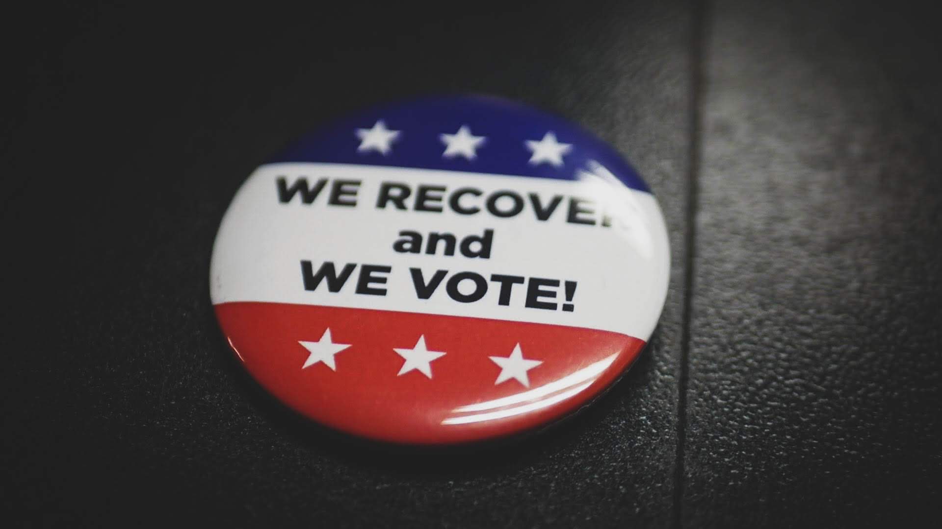 A pin that reads "We recover and we vote!"