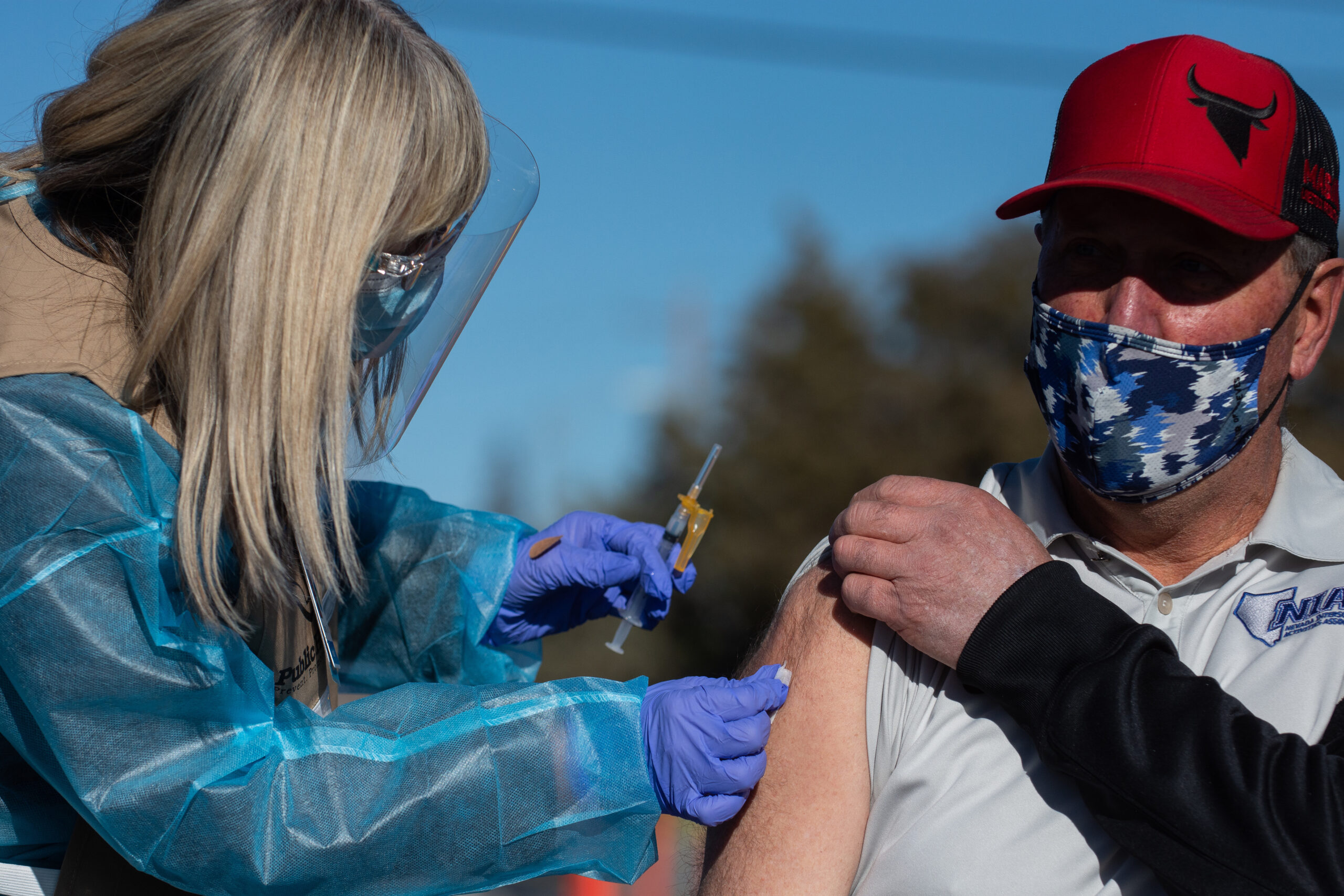 A man's arm is cleaned before receiving a vaccination.