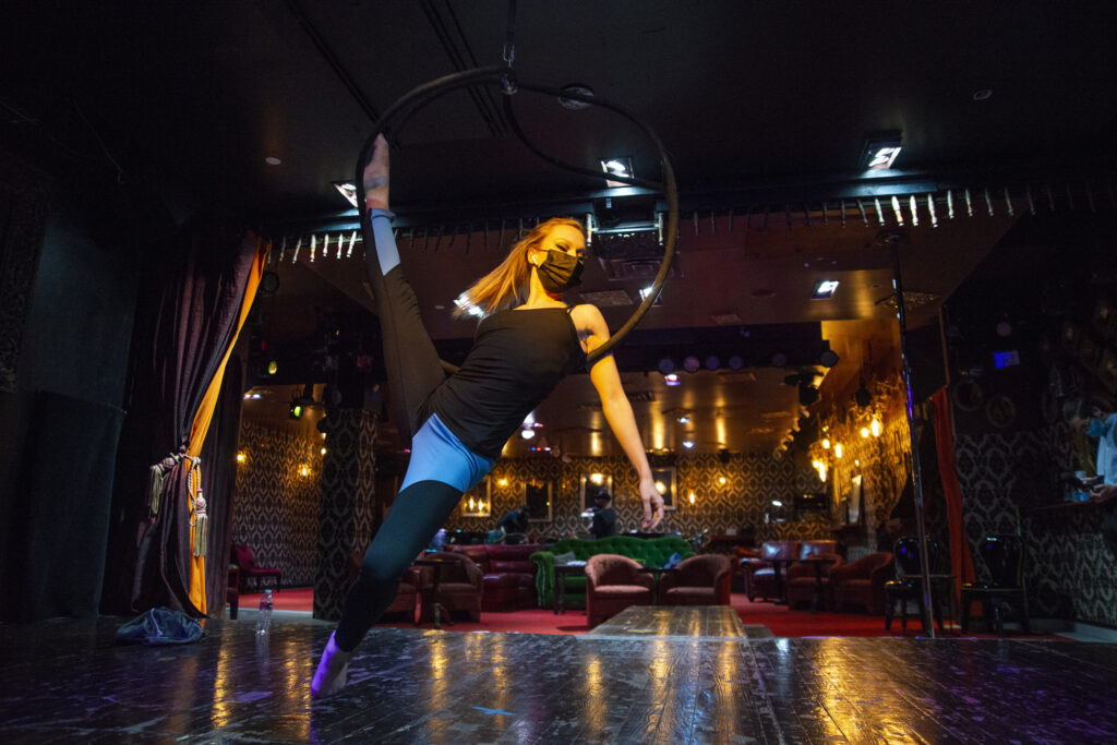 Angelique Janowski sits in a hoop hanging above a stage.