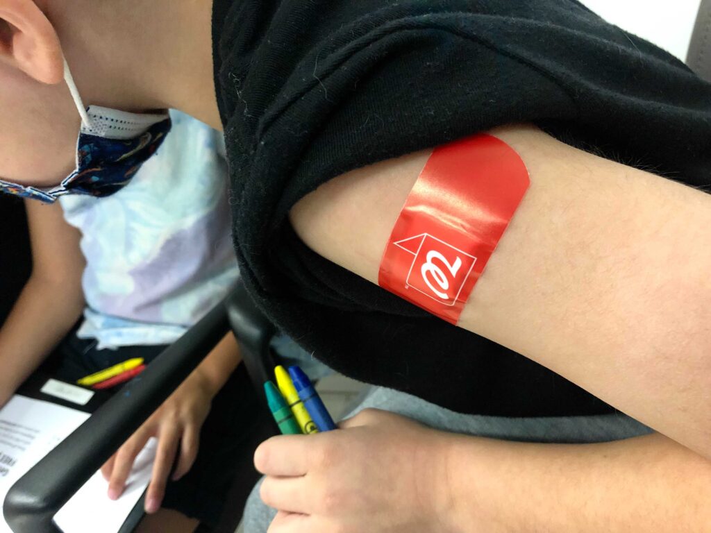 James, de 5 años, colorea después de recibir su primera dosis de la vacuna COVID-19 de Pfizer-BioNTech en un Walgreens de Henderson el sábado 6 de noviembre de 2021. (Daniel Clark/The Nevada Independent)