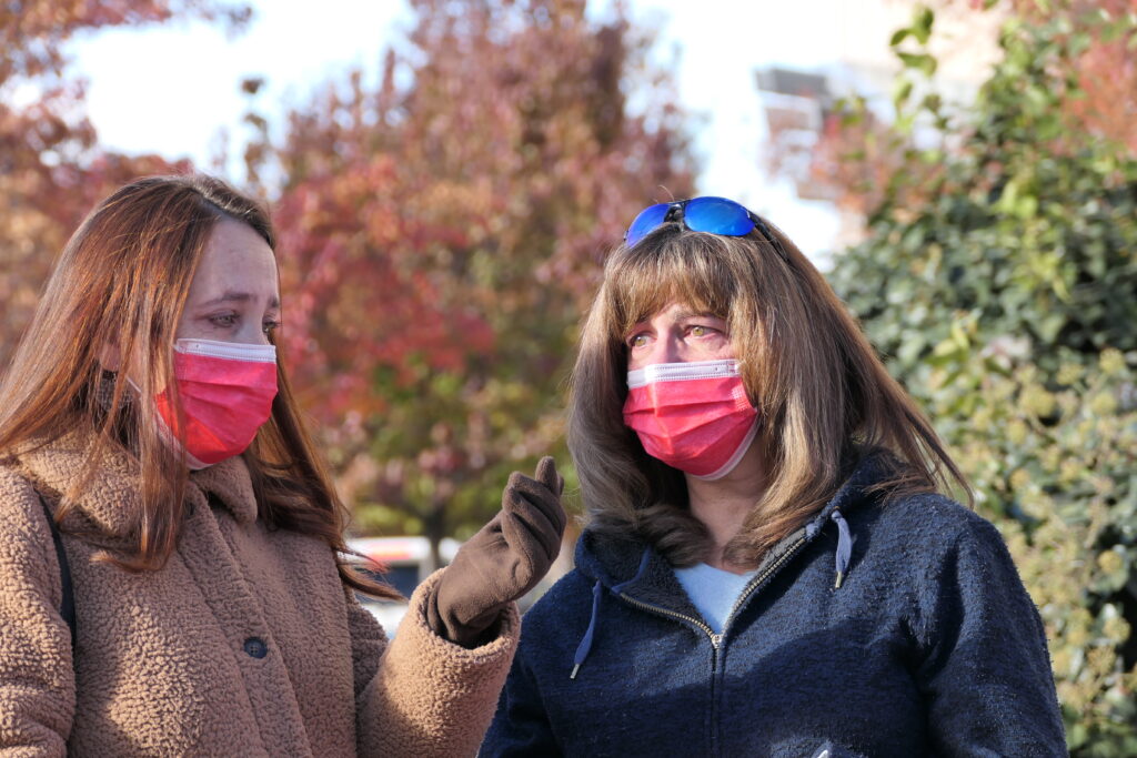 Two women looking upset in red medical masks