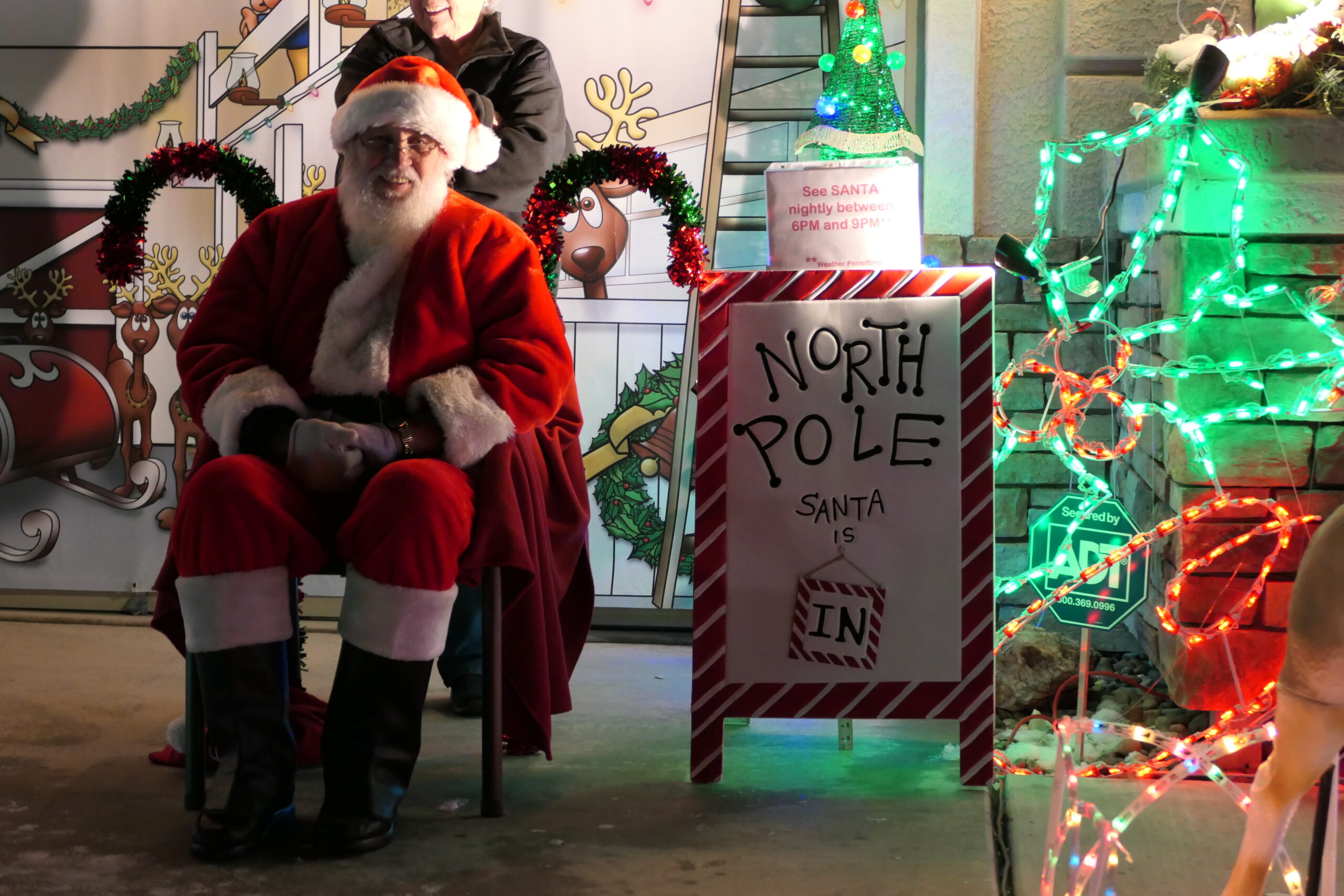 David Roberts dressed up as Santa Claus sits in front of his lights display the night of Dec. 11, 2022.