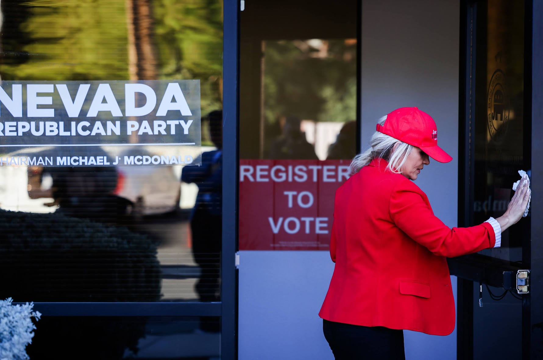 A volunteer cleans windows at the GOP headquarters in Henderson on Sunday, Nov. 6, 2022. (Jeff Scheid/The Nevada Independent).