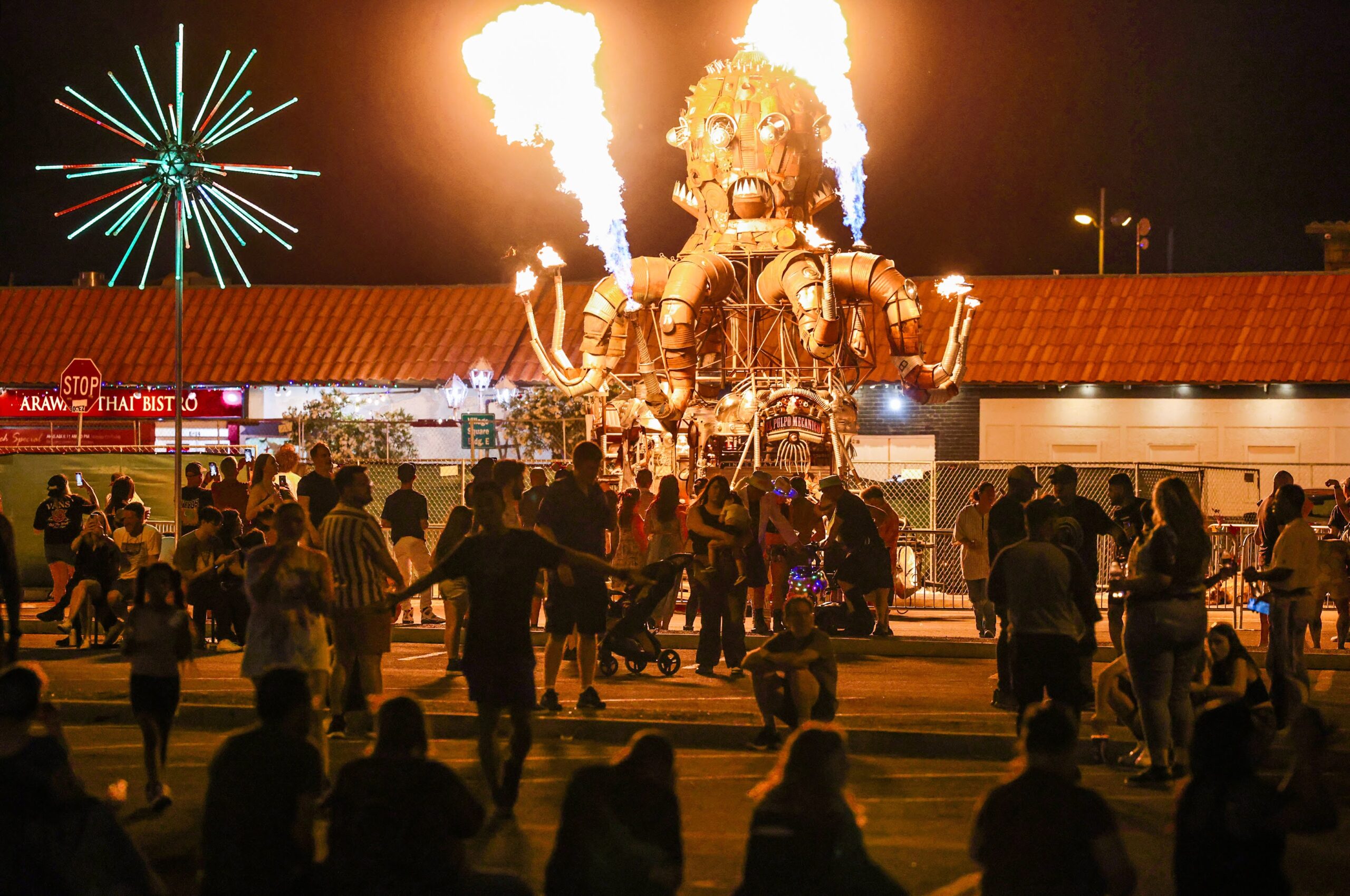 Guests gather around El Pulpo Mecanico, a 35-foot-tall mechanical fire spewing octopus, during The Fabulous Commercial Center Block Party on Thursday, May 18, 2023. (Jeff Scheid/The Nevada Independent)