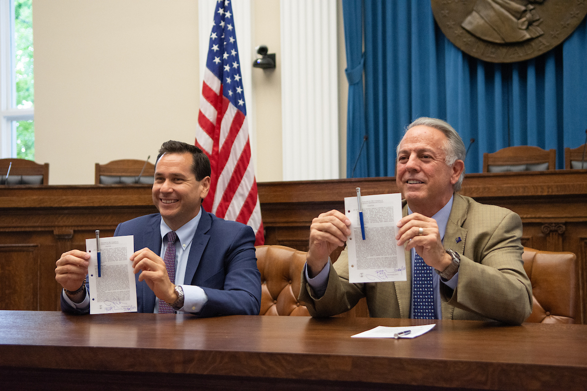 Gov. Joe Lombardo and Secretary of State Cisco Aguilar inside the old Assembly Chambers at the Capitol during a bill signing ceremony for SB406, introduced by Aguilar, which would make it a felony for any person to threaten election workers, in Carson City on May 30, 2023. (David Calvert/The Nevada Independent).