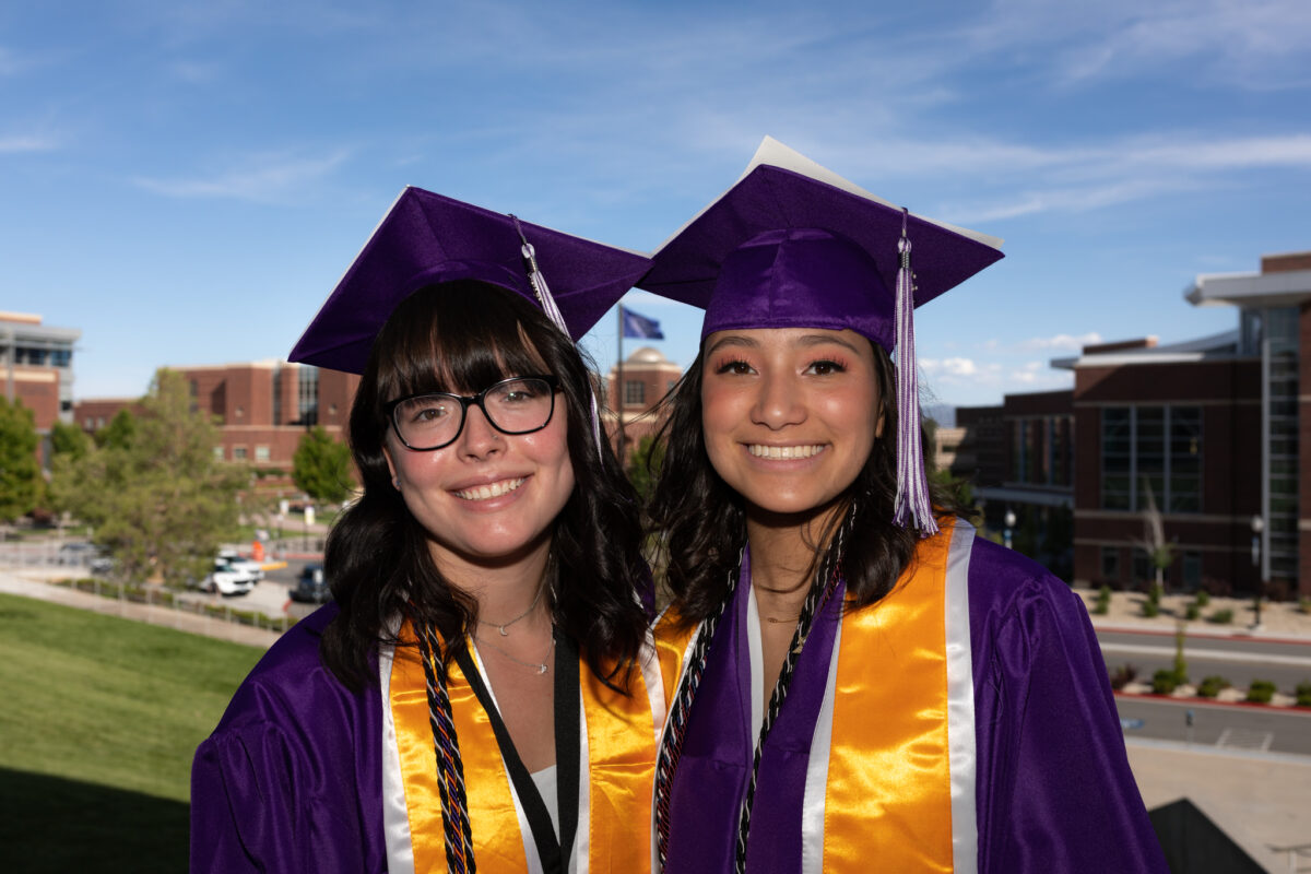 Spanish Springs High School students Camille Johnson, left, and Malia Lowery, right, show off their graduate cap designs outside of Lawlor Events Center in Reno on June 15, 2023. (Trevor Bexon/The Nevada Independent).