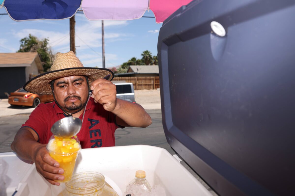 Street vendor Luis Sanchez makes a drink at his stand in North Las Vegas on Tuesday, June 13, 2023. (Jeff Scheid/The Nevada Independent)