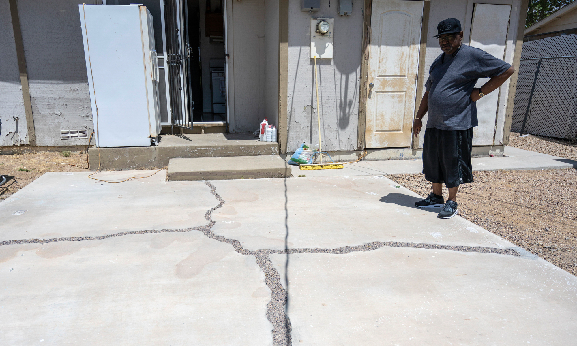 June Johnson stands on a patio that cracked and had to be filled in with rocks at his home in the Windsor Park neighborhood in North Las Vegas on Wednesday, May 10, 2023. (Daniel Clark/The Nevada Independent).