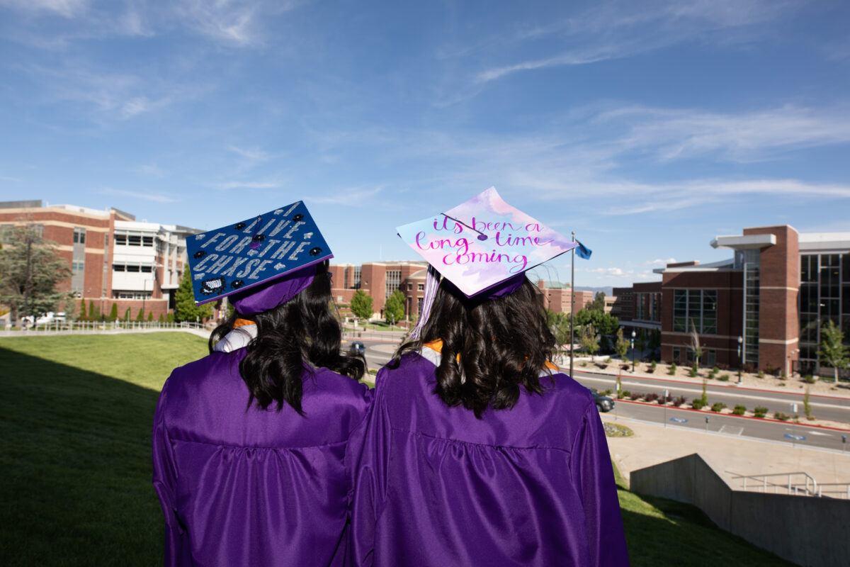 Spanish Springs High School students Camille Johnson, left, and Malia Lowery, right, show off their graduate cap designs outside of Lawlor Events Center in Reno on June 15, 2023. (Trevor Bexon/The Nevada Independent).