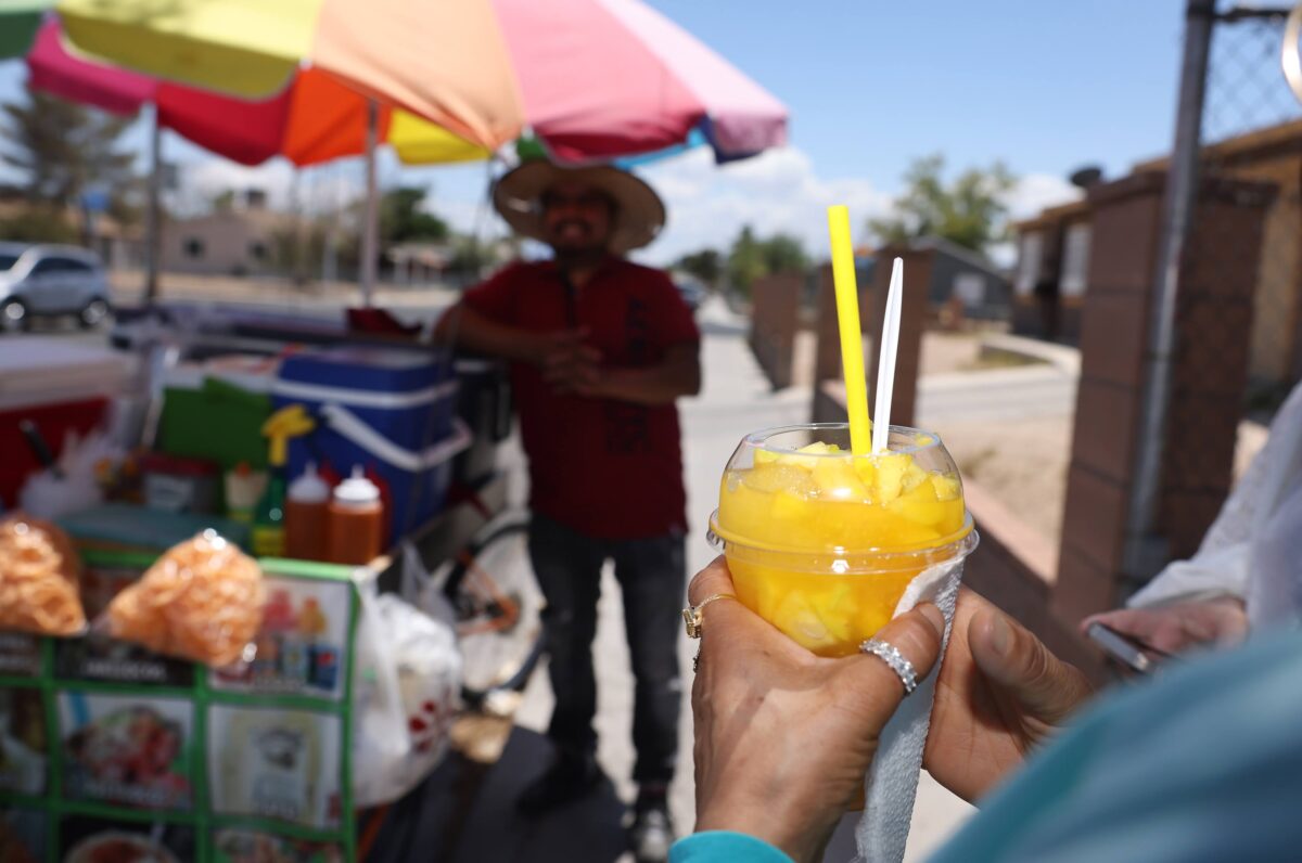 Street vendor Luis Sanchez talks to a costumer at his stand in North Las Vegas on Tuesday, June 13, 2023. (Jeff Scheid/The Nevada Independent)