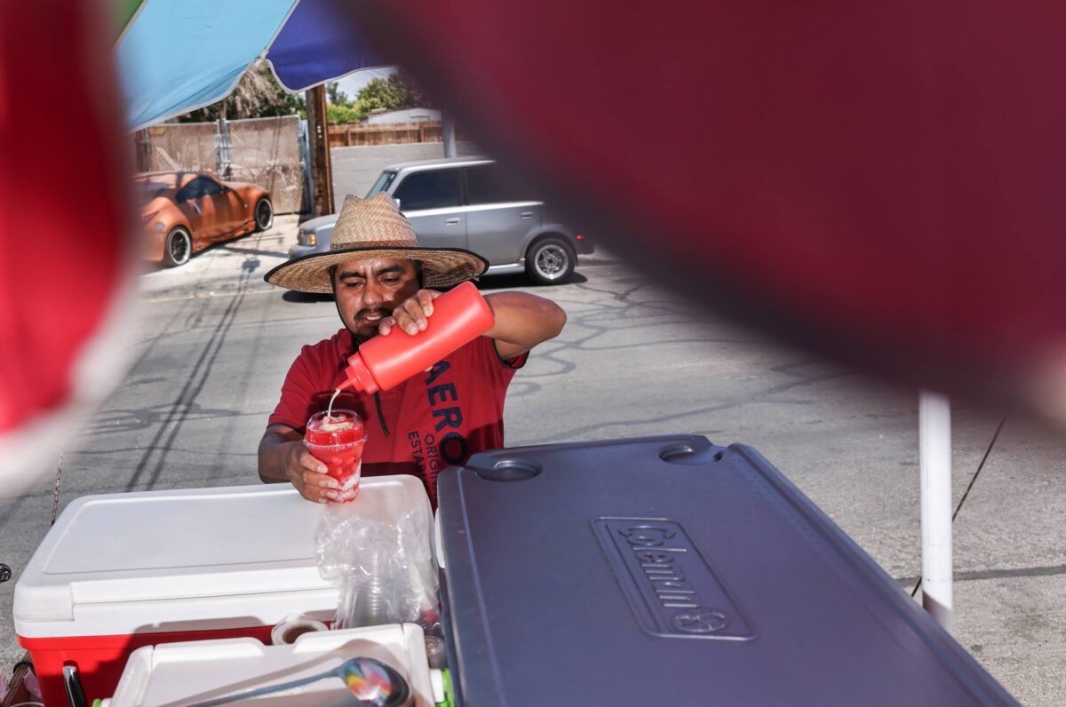 Street vendor Luis Sanchez  makes drinks at his stand in North Las Vegas on Tuesday, June 13, 2023. (Jeff Scheid/The Nevada Independent)