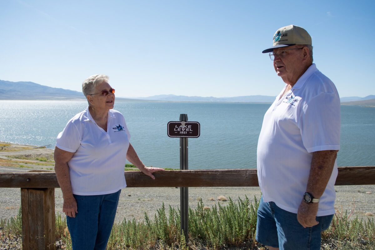 Glenn Bunch, president of the Walker Lake Working Group and his wife, Marlene, next to the a lake-level marker at Sportsman’s Beach at Walker Lake on June 22, 2023, near Hawthorne. (David Calvert/The Nevada Independent)