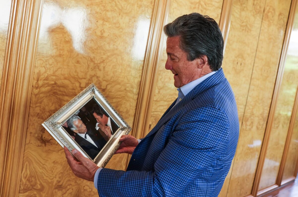 MGM Resorts International CEO Bill Hornbuckle looks at a photo of him talking to the late Las Vegas casino pioneer and MGM Resort founder Kirk Kerkorian during an interview in his office on Thursday, June 30, 2023. (Jeff Scheid/The Nevada Independent)